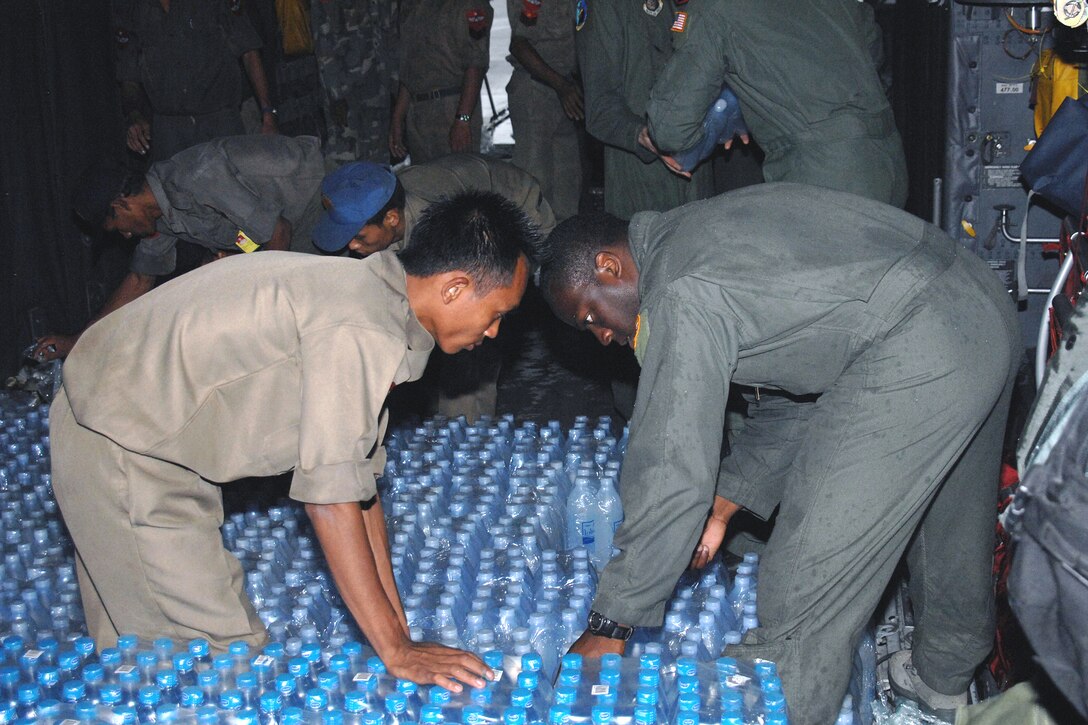 U.S. Air Force Capt. Kristopher Duckett and Burmese servicemembers unload humanitarian relief supplies from a U.S. Air Force C-130 Hercules aircraft at Yangon International Airport, Burma, May 19, 2008. Duckett, a pilot, is assigned to the 374th Airlift Wing, from Yokota Air Base, Japan. 