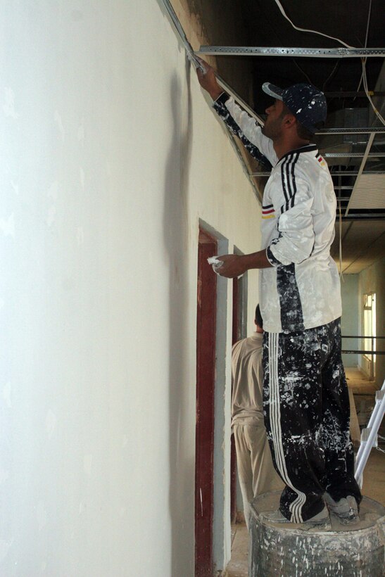 A local worker repairs the cracks in the wall of the courthouse in Rawah, Iraq, May 21. Repairing and repainting the walls are some of the final touches being put on the courthouse as Marines with Detachment 1, Civil Affairs Team 5, 2nd Battalion, 11th Marine Regiment, Regimental Combat Team 5, prepare to turn the building over to the city government. The building had been used by Coalition forces, but has recently been demilitarized.