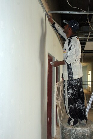 A local worker repairs the cracks in the wall of the courthouse in Rawah, Iraq, May 21. Repairing and repainting the walls are some of the final touches being put on the courthouse as Marines with Detachment 1, Civil Affairs Team 5, 2nd Battalion, 11th Marine Regiment, Regimental Combat Team 5, prepare to turn the building over to the city government. The building had been used by Coalition forces, but has recently been demilitarized.