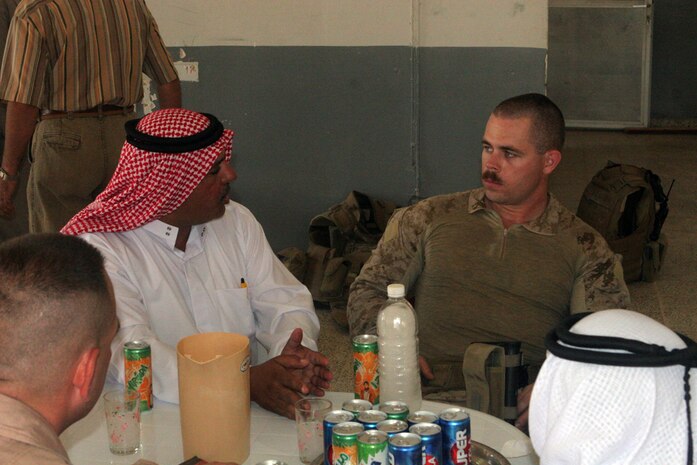 1st Lt. Daniel M. Thomas, team leader with Detachment 1, Civil Affairs Team 5, 2nd Battalion, 11th Marine Regiment, Regimental Combat Team 5, talks with one of the local contractors as they meet at the bank in Rawah, Iraq, May 21. The bank served as part of a post used by Coalition forces. The post was recently demilitarized, and Marines with CA Team 5 plan to have it renovated before it is turned over to the city government.