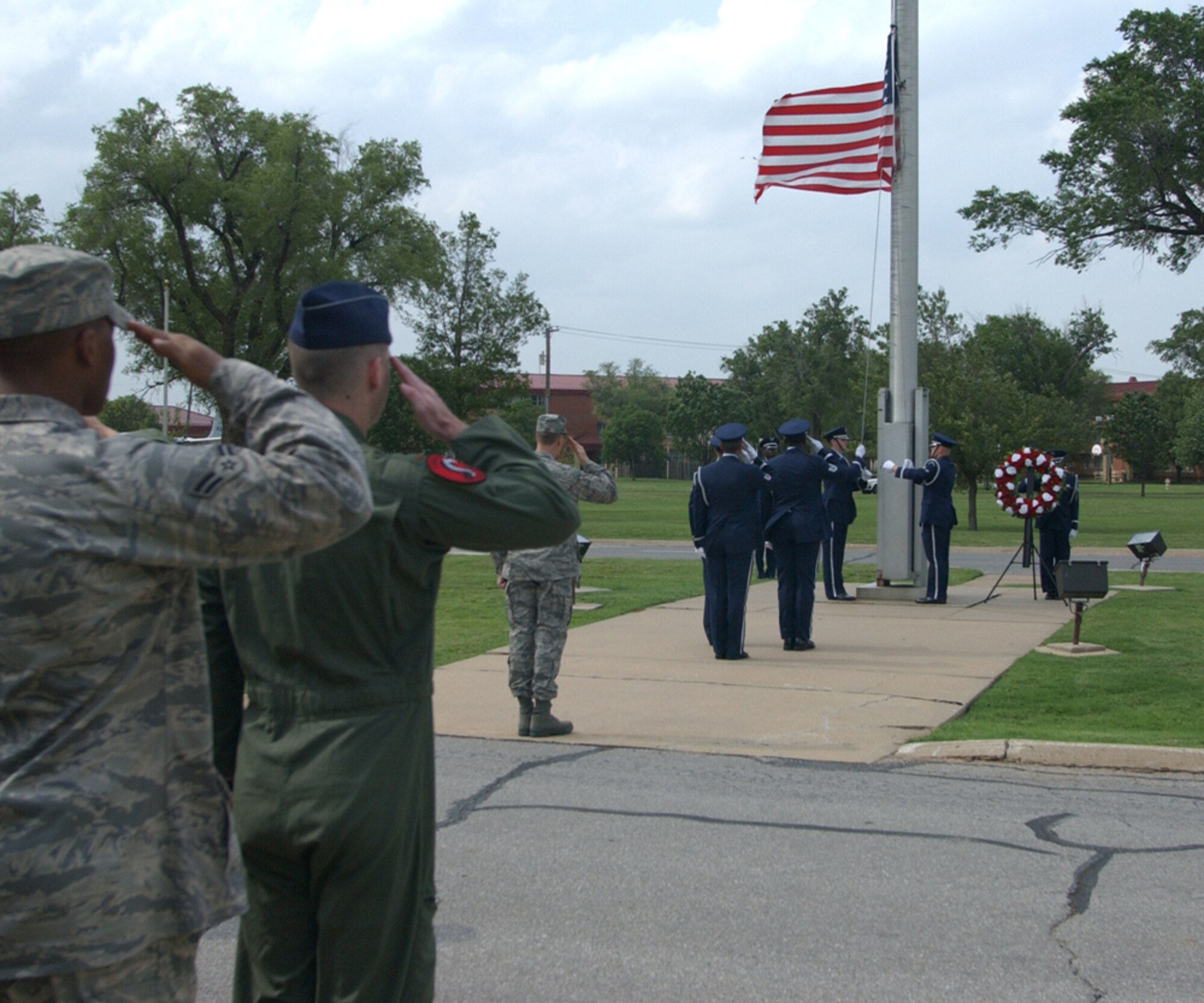 Team Vance members salute as the Silver Talon Honor Guard lowers the flag during a Memorial Day retreat ceremony honoring servicemembers who paid the ultimate sacrifice for freedom. (U.S. Air Force photo by Bob Farrell)