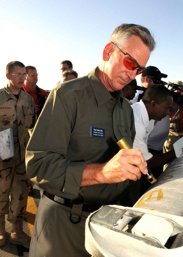 Auburn University head coach Tommy Tuberville signs a munition on the flightline in Southwest Asia May 22. (U.S. Air Force photo/Tech. Sgt. Johnny Saldivar) 