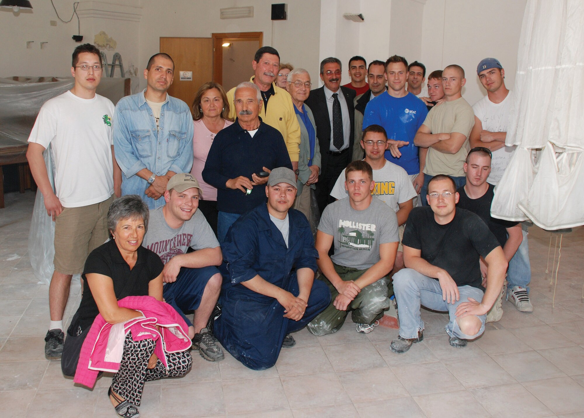 Airmen from the 31st Munitions Squadron at Camp Darby, Italy, and veterans of the Italian Folgore Parachutist Brigade take a break during the refurbishing of the Associazione Nazionale Paracadutisti D'Italia meeting hall in nearby Livorno. (U.S. Air Force photo/Joyce Costello) 
