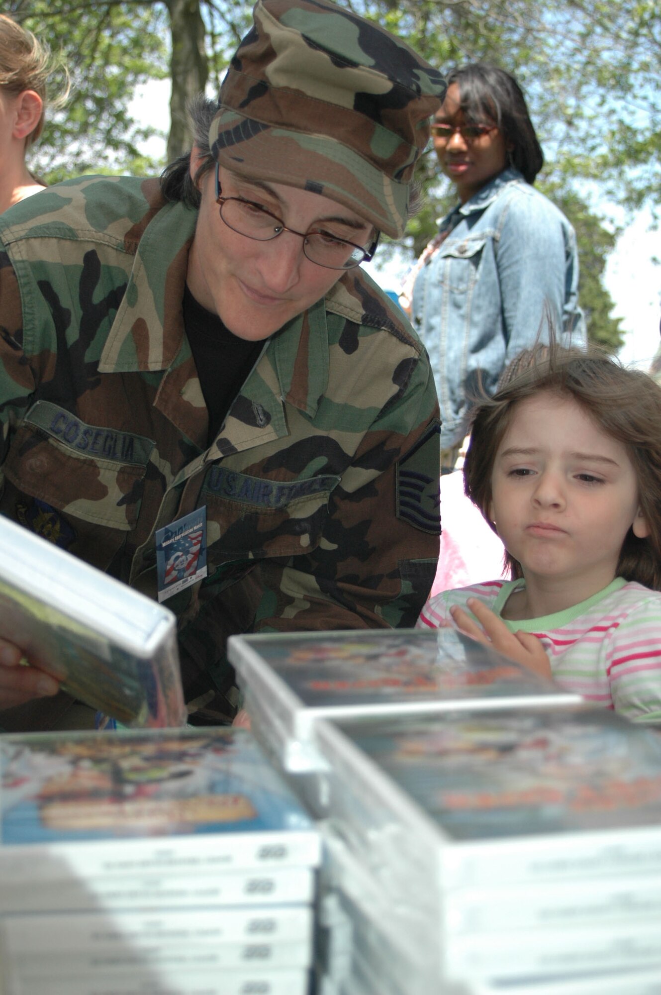 DOVER AIR FORCE BASE, Del. -- Master Sgt. Laura Coseglia, 512th Airman and Family Readiness chief, shows her daughter Darlene, 5, some of the free movies available to choose from at the the Hailing our Heroes and their Families Picnic May 17, Armed Forces Day, at the Eagle's Nest Picnic Area here from 11 a.m. to 4 p.m. USO Delaware, with the assistance of commercial sponsors, hosted the picnic for military members and their families. (U.S. Air Force photo/Senior Airman Sasha S. Skrine)