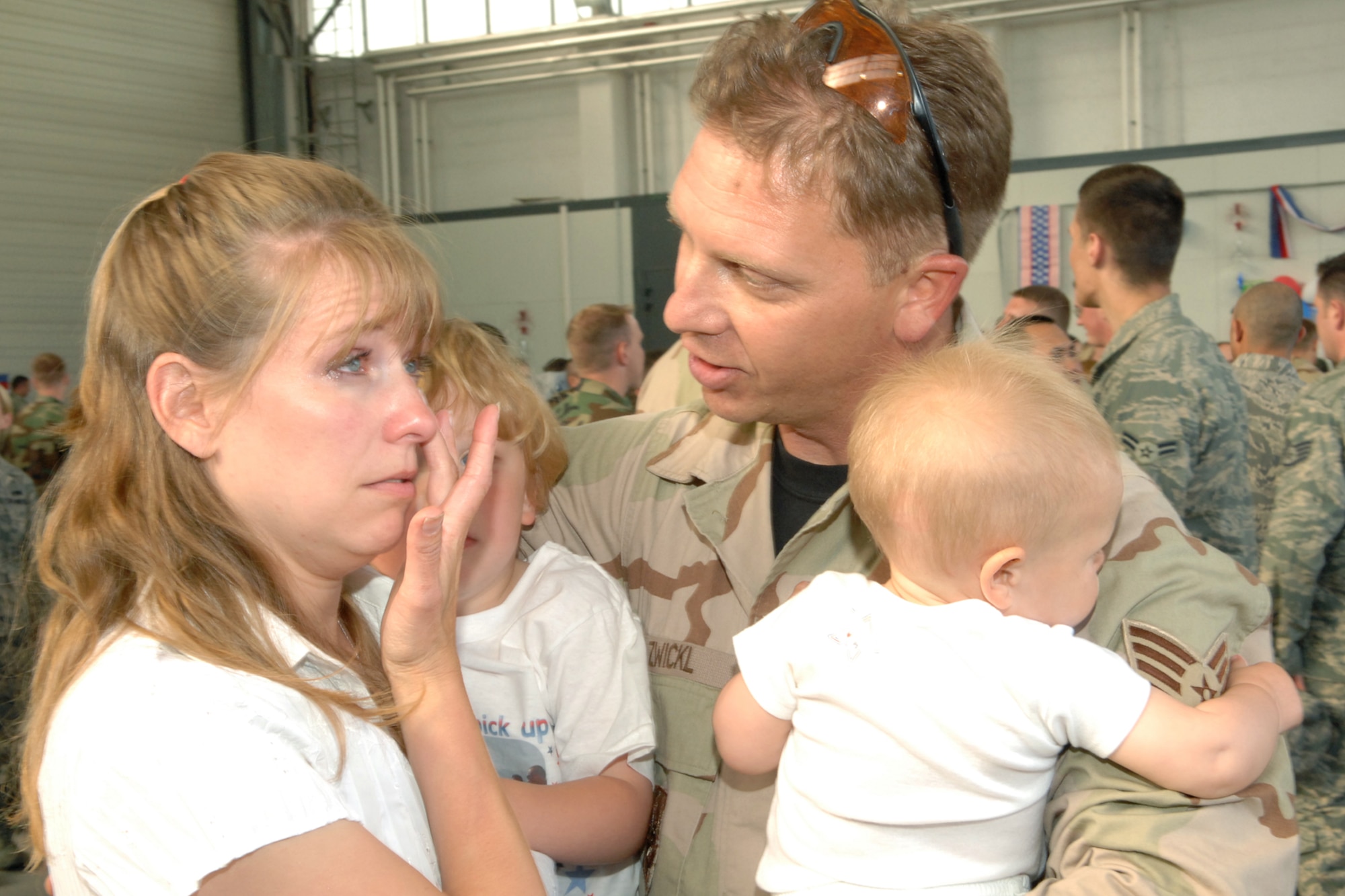 SPANGDAHLEM AIR BASE, Germany--  Tech. Sgt. Randall Zwickl, 52nd Aircraft Maintenance Squadron, hugs his wife and children upon returning from his 121-day deployment to Bagram Air Base, Afghanistan, May 20, 2008.  U.S. Air Force photo by Senior Airman Logan Tuttle.
