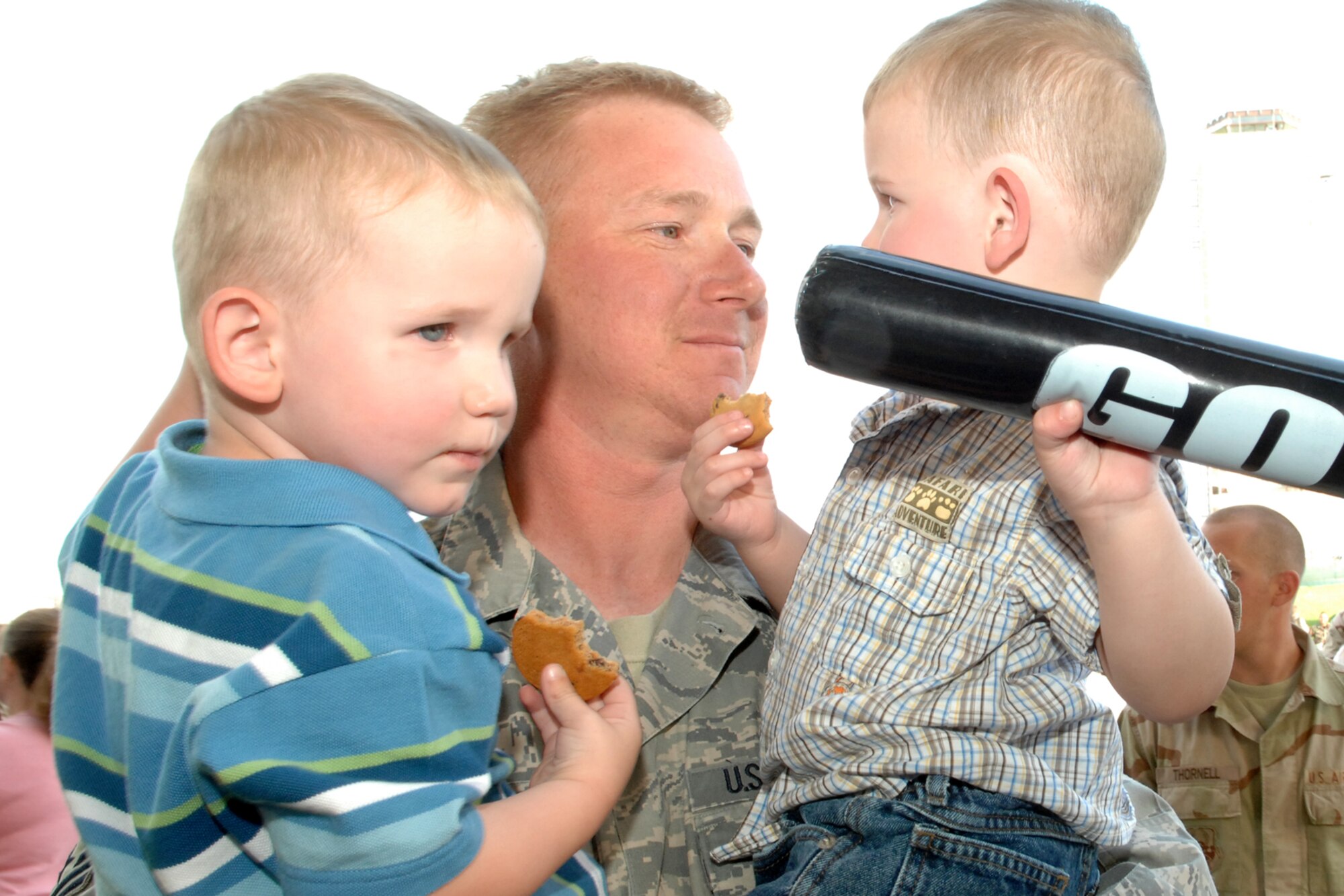 SPANGDAHLEM AIR BASE, Germany-- Master Sgt. Eric Oian, 52nd Equipment Maintenance Squadron, holds his sons upon returning from his 121-day deployment to Bagram Air Base, Afghanistan, May 20, 2008.  U.S. Air Force photo by Senior Airman Logan Tuttle.