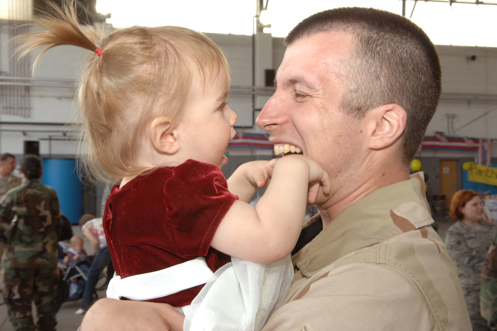 SPANGDAHLEM AIRBASE, Germany -- Staff Sgt Christopher Keller, 52nd Component Maintenance Squadron, plays with his daughter Evelyn upon returning from his 121-day deployment to Bagram Air Base, Afghanistan, May 20, 2008. U.S. Air Force photo by Senior Airman Logan Tuttle.