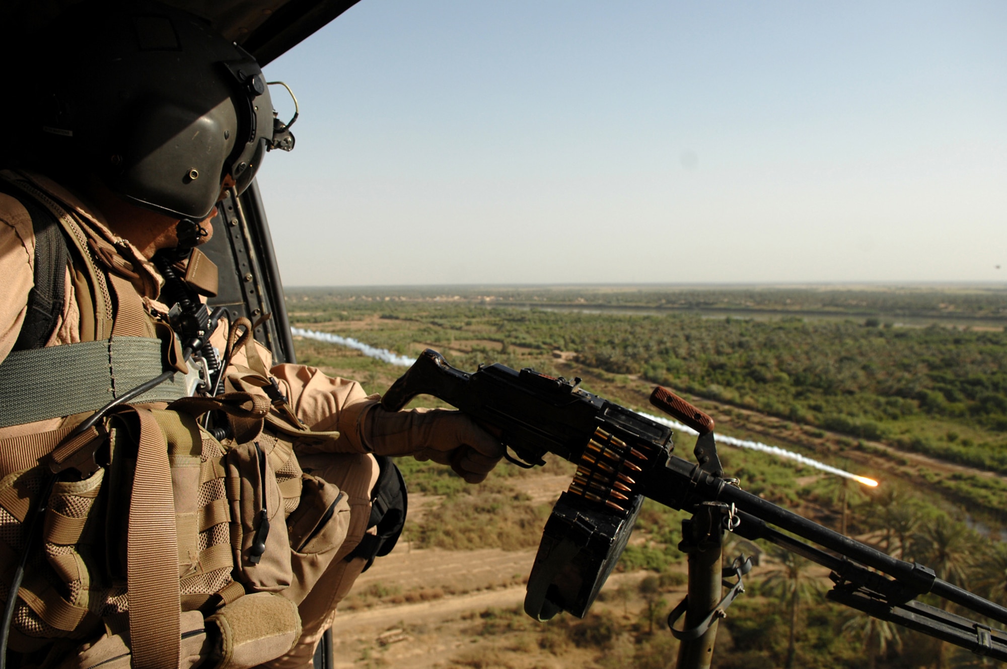 BALAD AIR BASE, Iraq -- Tech. Sgt. Anthony Taber, Multinational Security Transition Command-Iraq aerial gunner, performs air-to-ground reconnaissance on the way to Balad Air Base in a UH-1 Huey April 25. Sergeant Taber is deployed from Hurlburt Field, Fla. (U.S. Air Force photo/ Senior Airman Julianne Showalter)