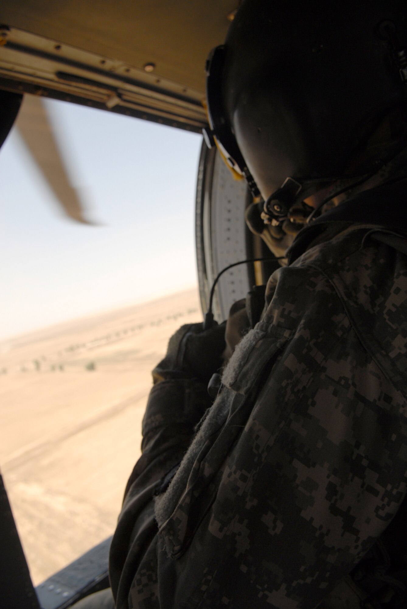 BALAD AIR BASE, Iraq -- Army Staff Sgt. Anthony Cox, a 7th Battalion, 101st Aviation Regiment flight medic, performs air-to-ground reconnaissance on the way to pick up a trauma patient from Camp Grizzly, May 20. The transportation from various forward operating bases and points of injury to the next level of medical care is a critical link in the chain of events to ensure patients are treated within one hour of being injured. Critically injured servicemembers and civilians are often brought to the Air Force Theater Hospital at Balad AB for treatment. The 7th Battalion, 101st Aviation Regiment is deployed from Fort Campbell, Ky. (U.S. Air Force photo/ Senior Airman Julianne Showalter)