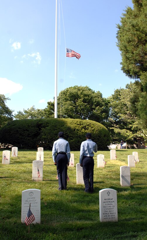 U.S. Navy sailors render salutes to the flag flown at half mast during the "Flags In" tribute to honor fallen heroes at Arlington National Cemetery, Va., May 22, 2008. The sailors are assigned to the U.S. Navy Ceremonial Guard.