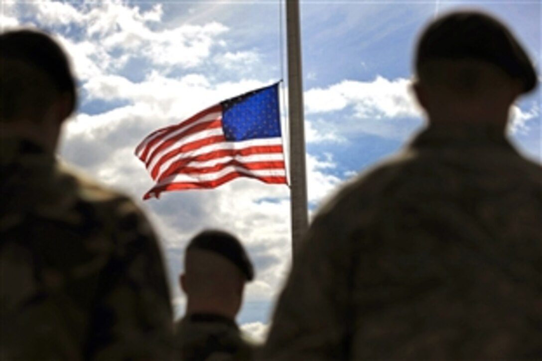 U.S. Air Force airmen watch the flag being lowered to half-staff during a Memorial Day retreat  on Ellsworth Air Force Base, S.D., May 15, 2008.   