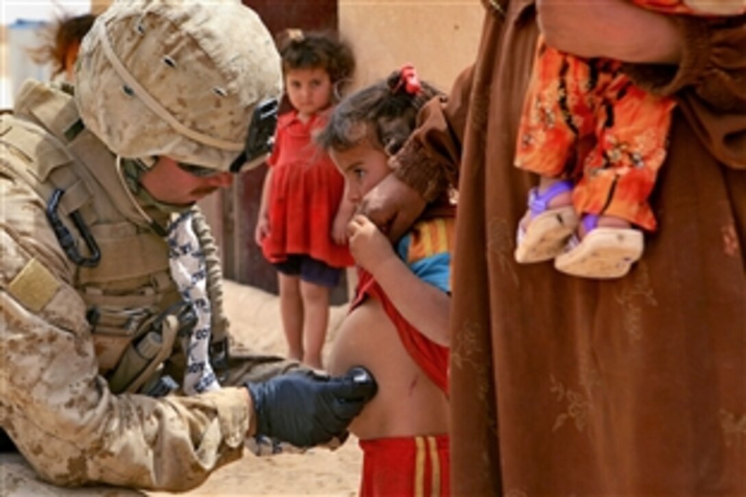 U.S. Navy sailor Gerald Dugger checks an Iraqi child, May 14, 2008. Duggar, a hospital corpsman, is assigned to the 1st Marine Expeditionary Force Personal Security Detail, Task Force Mameluke, Multinational Force West Ground Combat Element.