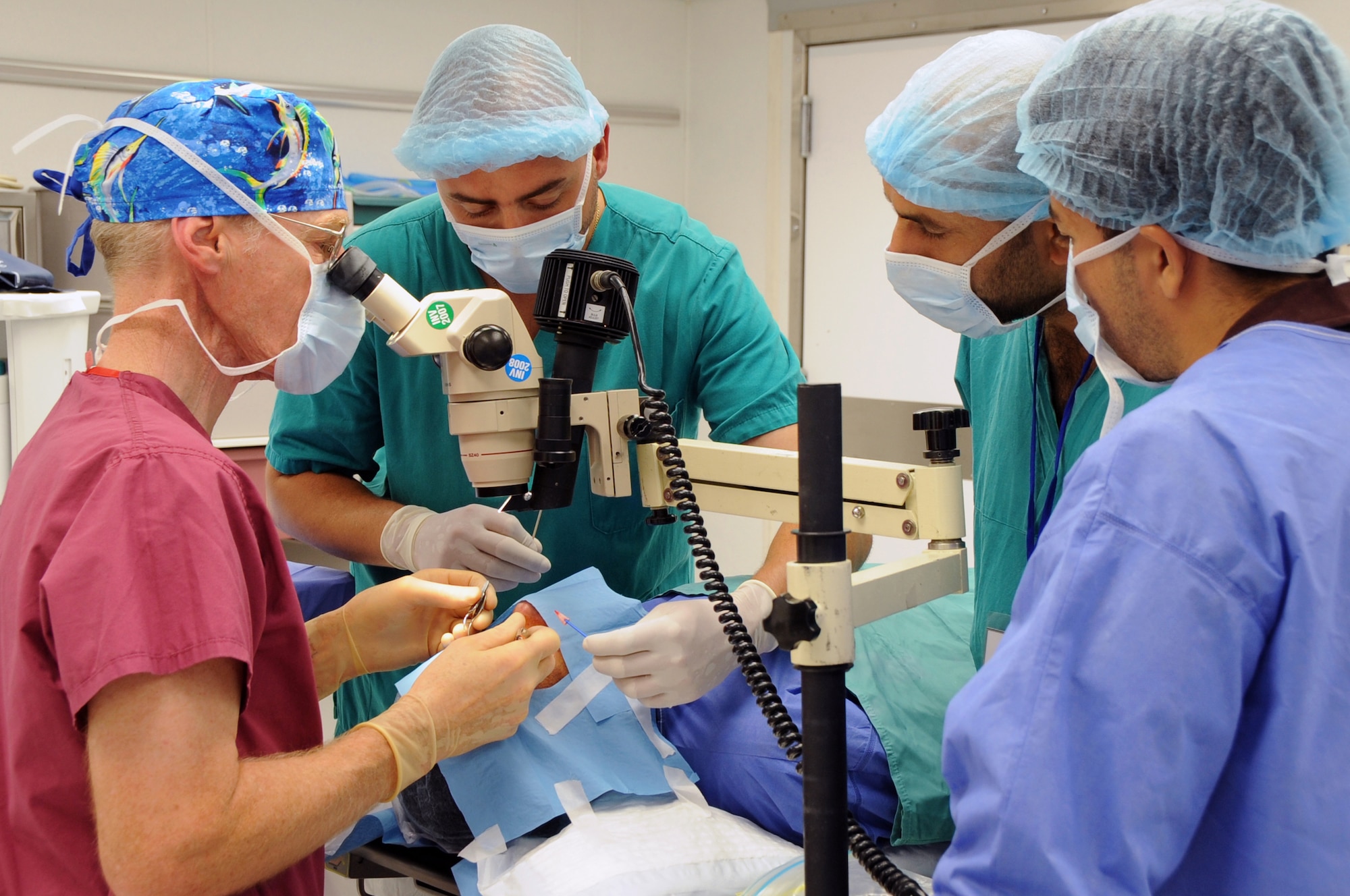 ALI BASE, Iraq -- Retired Air Force Colonel Stephen Waller, a contract ophthalmologist from Wilford Hall Medical Center, Lackland AFB, Texas, works with his medical team to perform an eye surgery here May 20. His team is comprised of two Iraqi doctor's assistants from the Nasiriyah General Hospital and two provincial reconstruction team members. The doctor came to Iraq to provide eye exams, surgeries and free glasses to hundreds of Iraqis in need. Dr. Waller arrived here May 18 and finished his humanitarian mission four days later. (U.S. Air Force photo/Tech. Sgt. Sabrina Johnson)