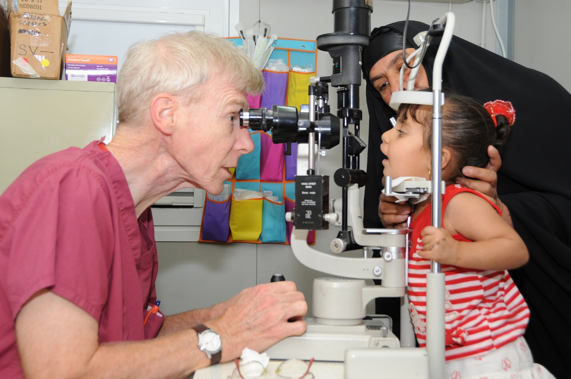 ALI BASE, Iraq -- Retired Air Force Colonel Stephen Waller, a contract ophthalmologist from Wilford Hall Medical Center, Lackland AFB, Texas, performs a routine eye exam on a young Iraqi child here May 20. The doctor came to Iraq to provide eye exams, surgeries and free glasses to hundreds of Iraqis in need. Dr.  Waller arrived here May 18 and finished his humanitarian mission four days later. (U.S. Air Force photo/Tech. Sgt. Sabrina Johnson)