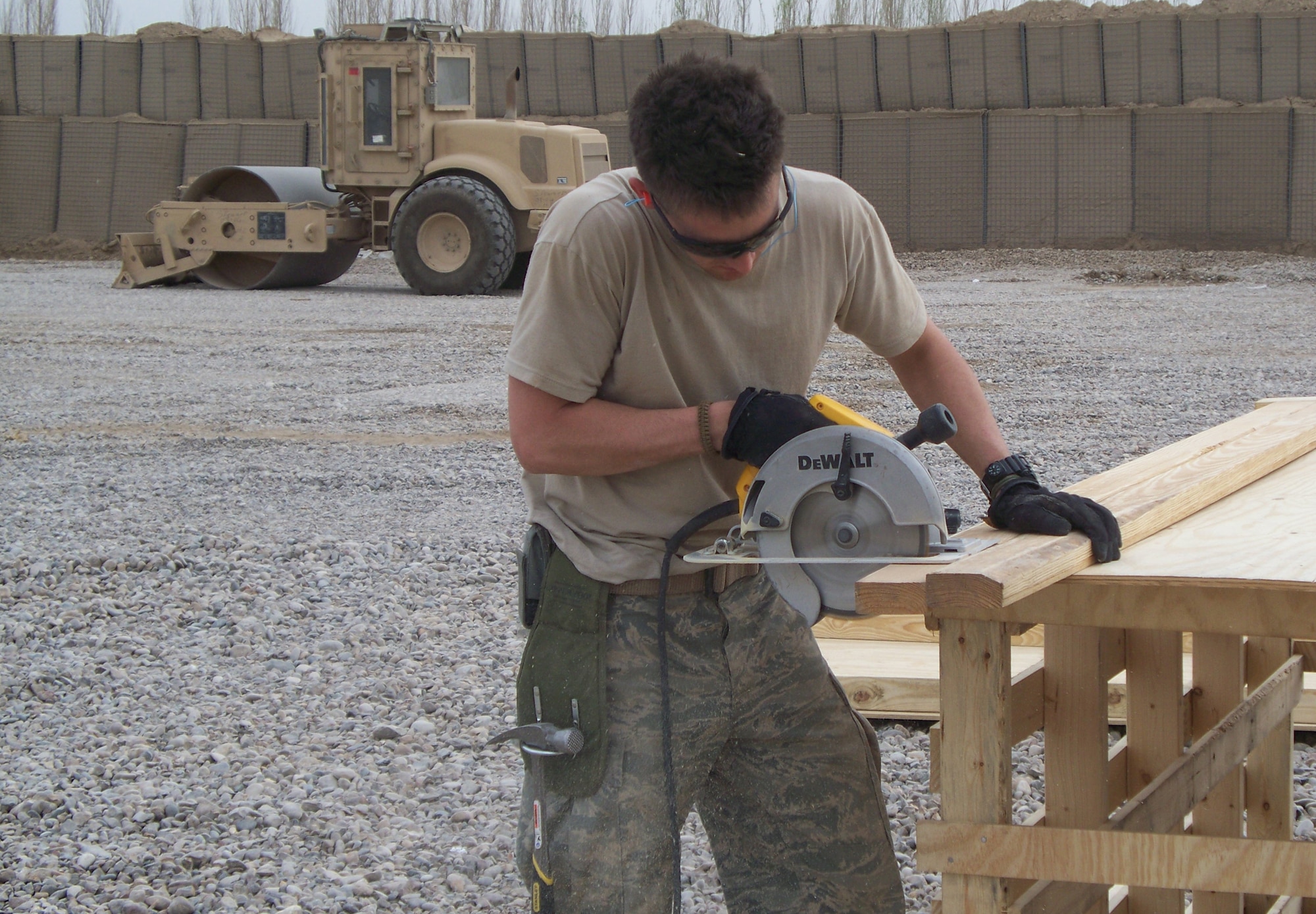 JOINT COMBAT OUTPOST MILLEDGE, Iraq -- Airman 1st Class John Owings, 732nd Expeditionary Civil Engineer Squadron, structural journeyman, saws wall studs to be used in the construction of buildings at the new Joint Combat Outpost Milledge, Iraq. The construction of the JCOP provides U.S. forces the ability to quickly respond and counter enemy actions in the Diyala River Valley. This area had been an Al Qaeda in Iraq stronghold and was previously considered a safe haven for insurgents in the Diyala Province. Airman Owings is deployed from Minot Air Force Base, N.D. (U.S. Air Force photo/ Airman 1st Class Nicholas Lane)