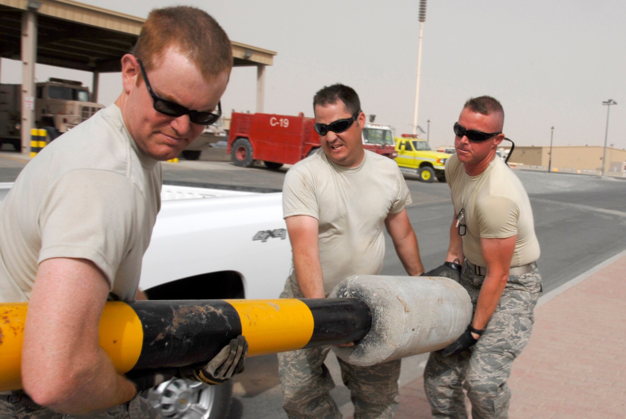 SOUTHWEST ASIA -- Staff Sgt. David Thain (left), Tech. Sgt. Dirk Mancuso (center), and Tech. Sgt. Donald Moore, all deployed to the 386th Expeditionary Civil Engineer Squadron, use team work to move a new traffic bollard May 21, 2008, at an air base in the Persian Gulf Region. Members from the 386th ECES are installing new traffic bollards to improve force protection on the air base. Sergeant Thain is deployed from the Utah Air National Guard’s 151st Air Refueling Wing in Salt Lake City, Sergeant Mancuso is deployed from the Louisiana ANG’s 159th Fighter Wing in New Orleans, and Sergeant Moore is deployed from the Mississippi ANG’s 186th Air Refueling Wing in Meridian, Miss. (U.S. Air Force photo/ Staff Sgt. Patrick Dixon)
