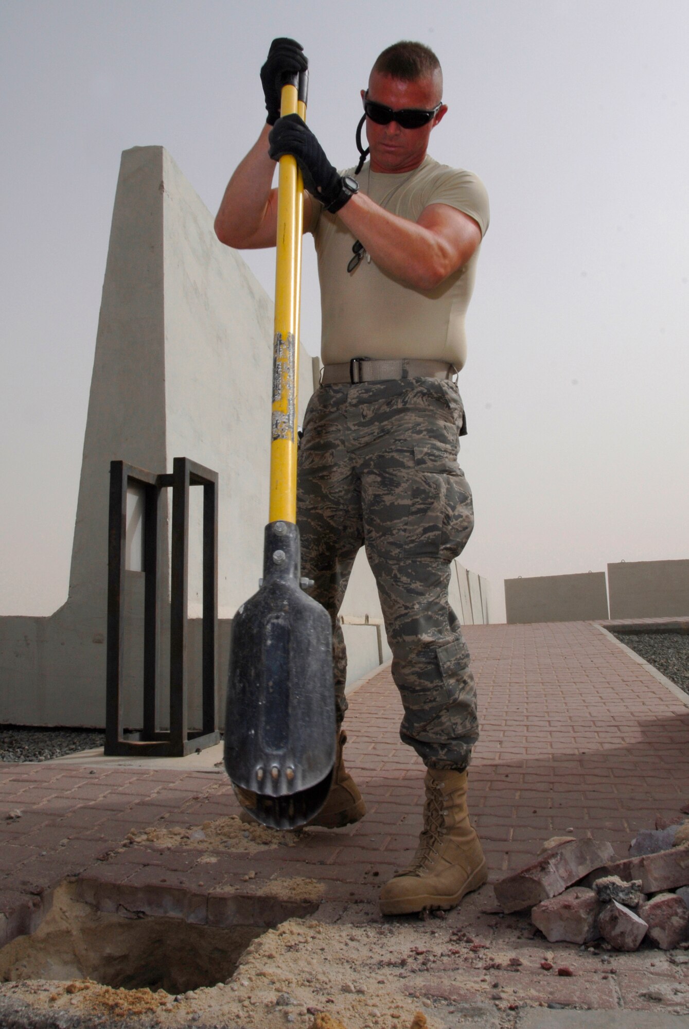 SOUTHWEST ASIA -- Technical Sgt. Donald Moore, deployed to the 386th Expeditionary Civil Engineer Squadron, uses a post shovel to remove dirt out of a hole for a new traffic bollard May 21, 2008, at an air base in the Persian Gulf Region. Members from the 386th ECES are installing new traffic bollards to improve force protection on the air base. Sergeant Moore is deployed from the Mississippi Air National Guard’s 186th Air Refueling Wing in Meridian, Miss. (U.S. Air Force photo/ Staff Sgt. Patrick Dixon)