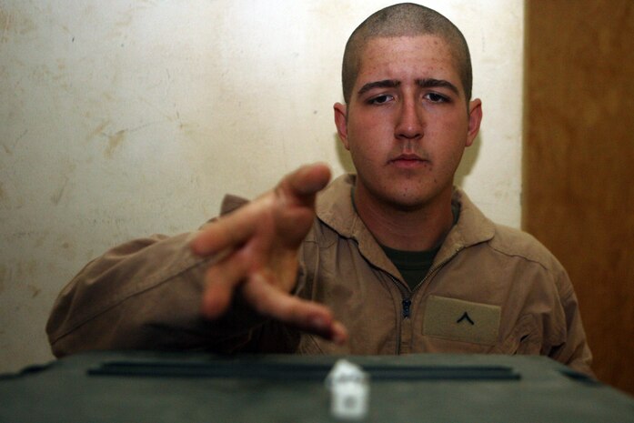 Pfc. Kyle D. Alders, a scout with Charlie Company, 2nd Light Armored Reconnaissance Battalion, Regimental Combat Team 5, rolls dice while relaxing between missions at Camp Korean Village, Iraq, May 23. The 19-year-old from West Palm Beach, Fla., assisted the worldâ??s blind community by taking part in the invention of a device known as the PAC-MATE.  When Alders is not patrolling the desert with Charlie Co., he is often found doing card tricks or playing board games.