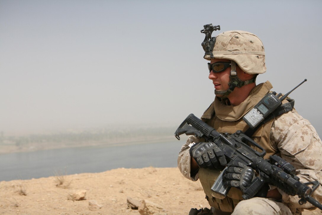 Lance Cpl. Jordan R. Brand, 21, a machine gunner from Papillion, Neb., assigned to Company L, 3rd Battalion, 4th Marine Regiment, Regimental Combat Team 5, provides security while Marines with Company L patrol the Euphrates River on boats May 25. Marines on the shore provided security for Marines conducting cache sweeps on islands in the river near Haditha, Iraq.