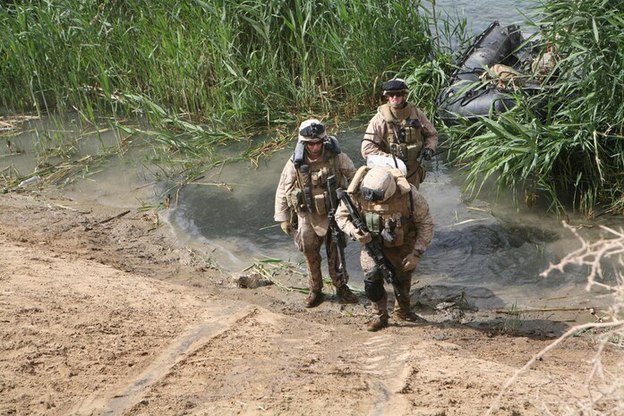 Marines with Company L, 3rd Battalion, 4th Marine Regiment, Regimental Combat Team 5 exit the Euphrates River drenched up to their waists May 25. Marines conducted cache sweeps on islands in the river near Haditha, Iraq. At every stop, Marines had to jump out of their boats into the water to get to an island.