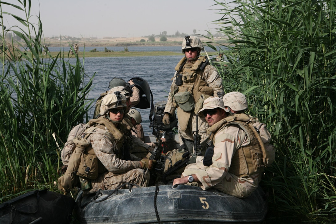 Marines with 3rd Platoon, Company L, 3rd Battalion, 4th Marine Regiment, Regimental Combat Team 5 head into the Euphrates River near Haditha, Iraq, May 25. Sailors with Riverine Squadron 3, Detachment 3, RCT-5, assisted Marines in the mission of clearing islands in the river. Sailors provided Marines a ride from one island to another. The Marines and sailors battled through scorching heat to accomplish the objective.