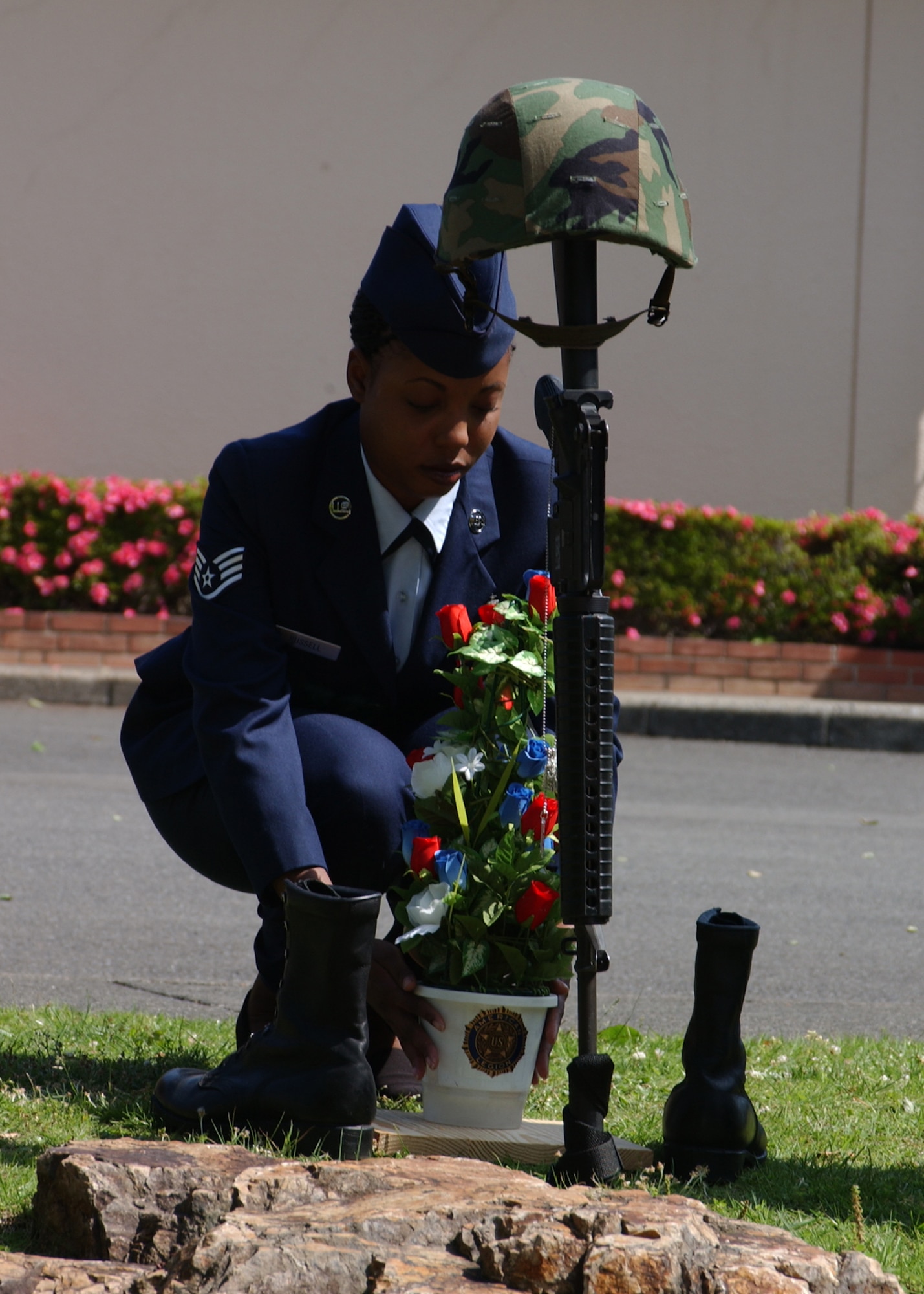 YOKOTA AIR BASE, Japan - Staff Sergeant Nicole Russell, from the 374th Dental Squadron, places flowers to finish a memorial for fallen soldiers during the American Legion's Memorial Day ceremony on May 26. The ceremony is held every in honor of those military members who have died serving. (U.S. Air Force photo by Airman 1st Class Jonathan Fowler)                                    