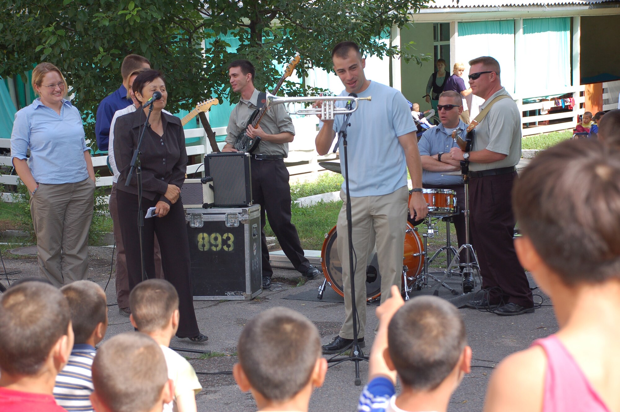 (08/05/25) MANAS AB, KYRGYZSTAN – Senior Airman Dave Evans, U.S. Air Forces Central Band Thunder Roll trumpet player, demonstrates the trumpet for the children at the Belovodosky Orphanage.  The AFCENT band performed at the orphanage and explained the different instruments the band uses during their visit.  (U.S. Air Force/TSgt Jerome Baysmore/ Released)