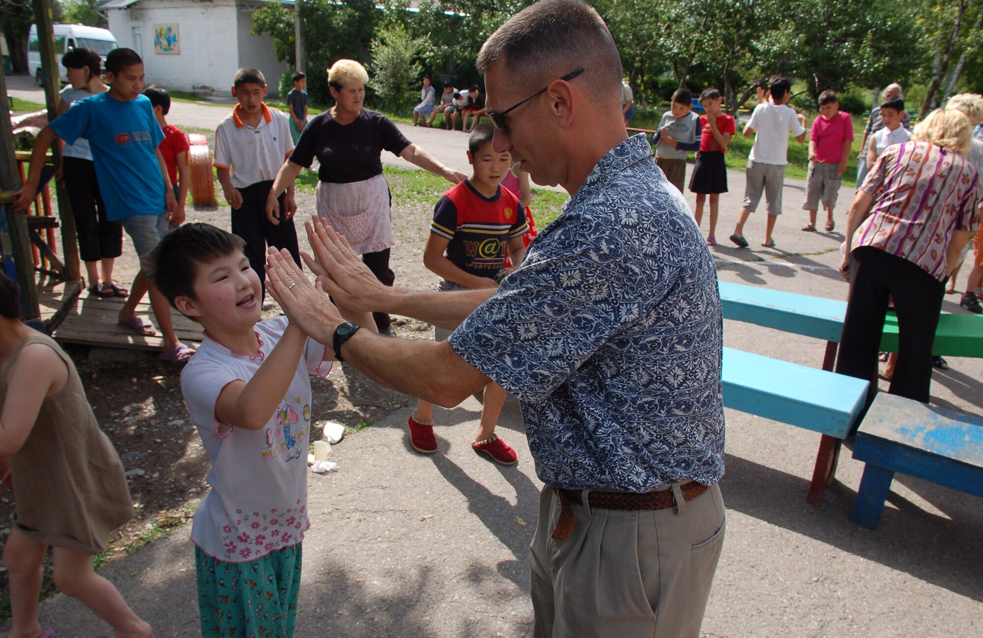(08/05/25) MANAS AB, KYRGYZSTAN – Master Sgt. Douglas Sheaffer, U.S. Air Forces Central Band Thunder Roll, enjoys a moment with the Belovodosky Orphanage children.  The AFCENT band performed at the orphanage and explained the different instruments the band uses during their visit.  (U.S. Air Force/TSgt Jerome Baysmore/ Released)