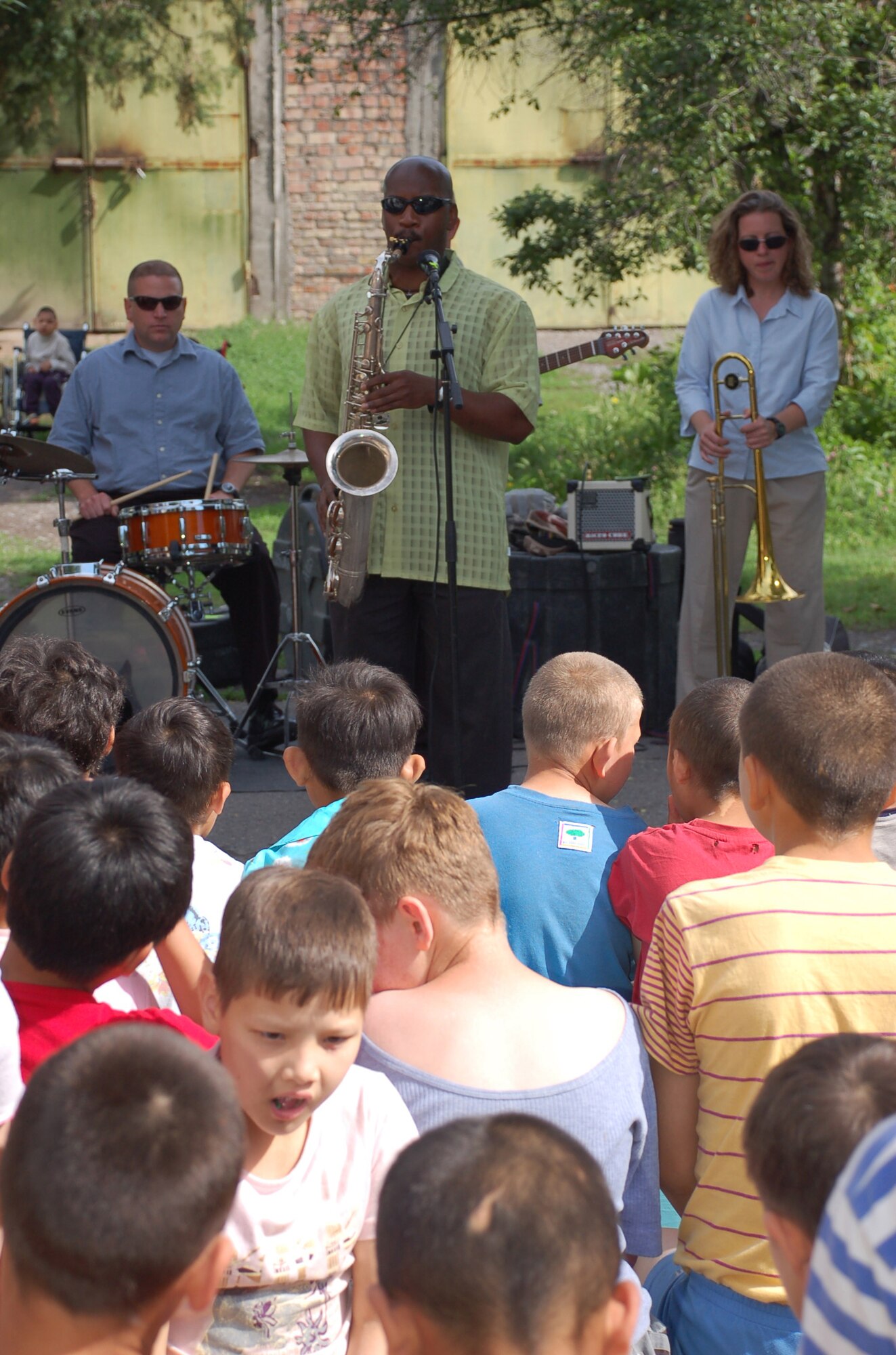 (08/05/25) MANAS AB, KYRGYZSTAN – Senior Airman Cedric Mayfield, U.S. Air Forces Central Band Thunder Roll saxophonist, plays a solo at the Belovodosky Orphanage.  The AFCENT band performed at the orphanage and explained the different instruments the band uses during their visit.  (U.S. Air Force/TSgt Jerome Baysmore/ Released)
