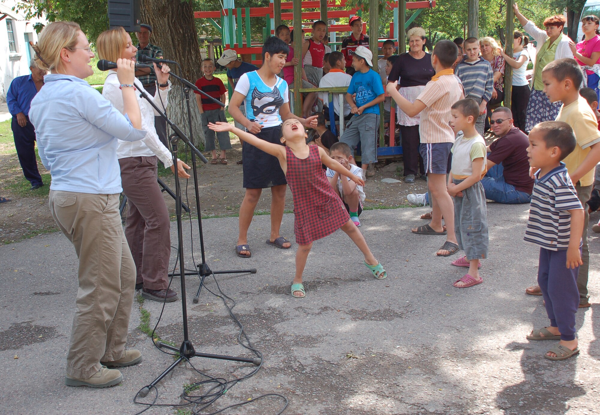 (08/05/25) MANAS AB, KYRGYZSTAN -- Staff Sgts. Mary Beth McFann and Rebecca Packard, U.S. Air Forces Central Band Thunder Roll vocalists, performs at the Belovodosky Orphanage.  The AFCENT band performed at the orphanage and explained the different instruments the band uses during their visit.  (U.S. Air Force/TSgt Jerome Baysmore/ Released)