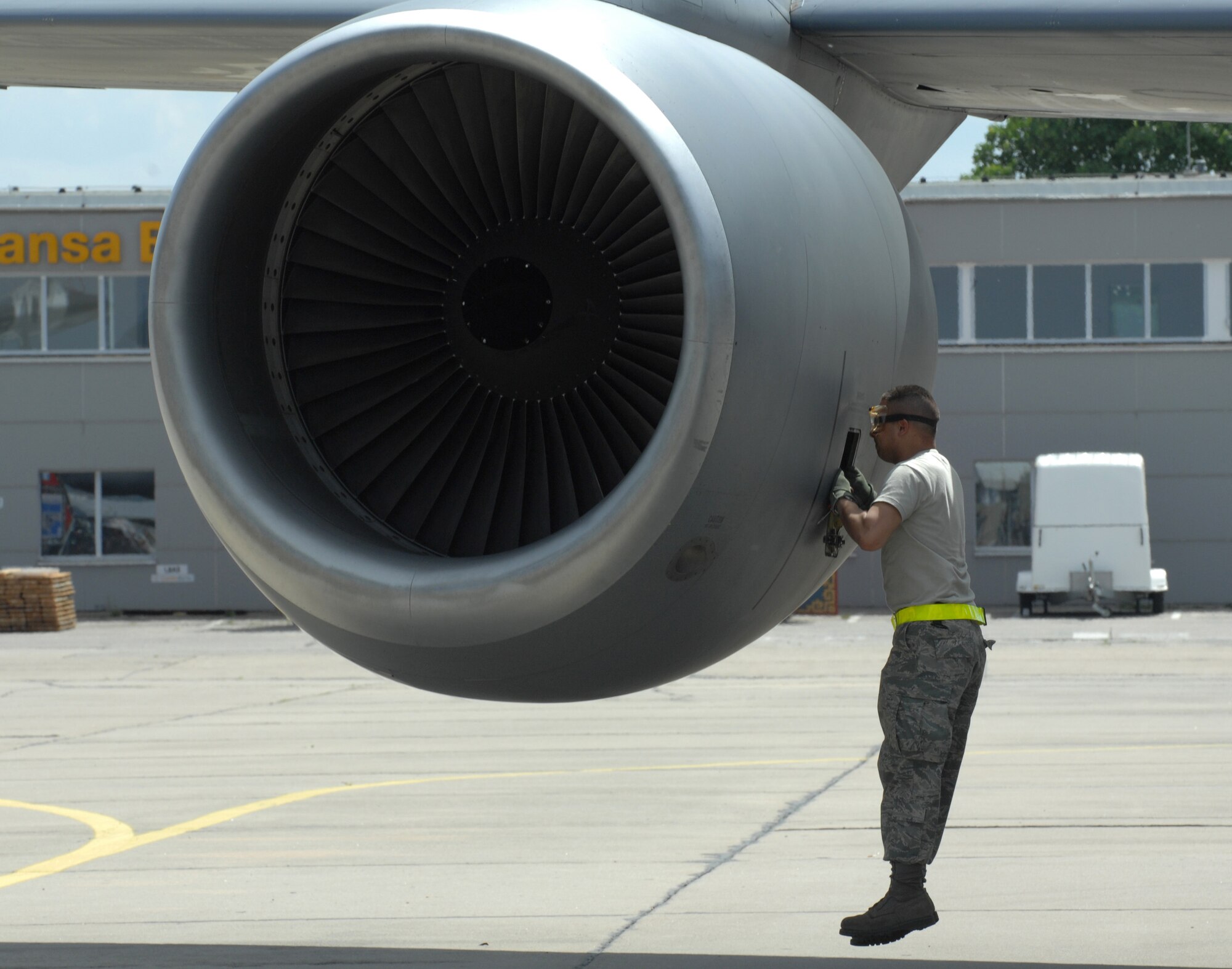 BERLIN, Germany - In the absence of a ladder, Staff Sgt. Brandon Sroufe still checks the oil on a KC-135R Stratotanker refueler aircraft by making a few short leaps during post flight inspections here May 25.  Sgt. Sroufe, along with the KC-135R, hails from the 100th Air Refueling Wing at Royal Air Force Mildenhall, UK, and is preparing for the 2008 Berlin Air Show to take place the rest of the week. (U.S. Air Force photo by Tech. Sgt. Corey Clements) (released)