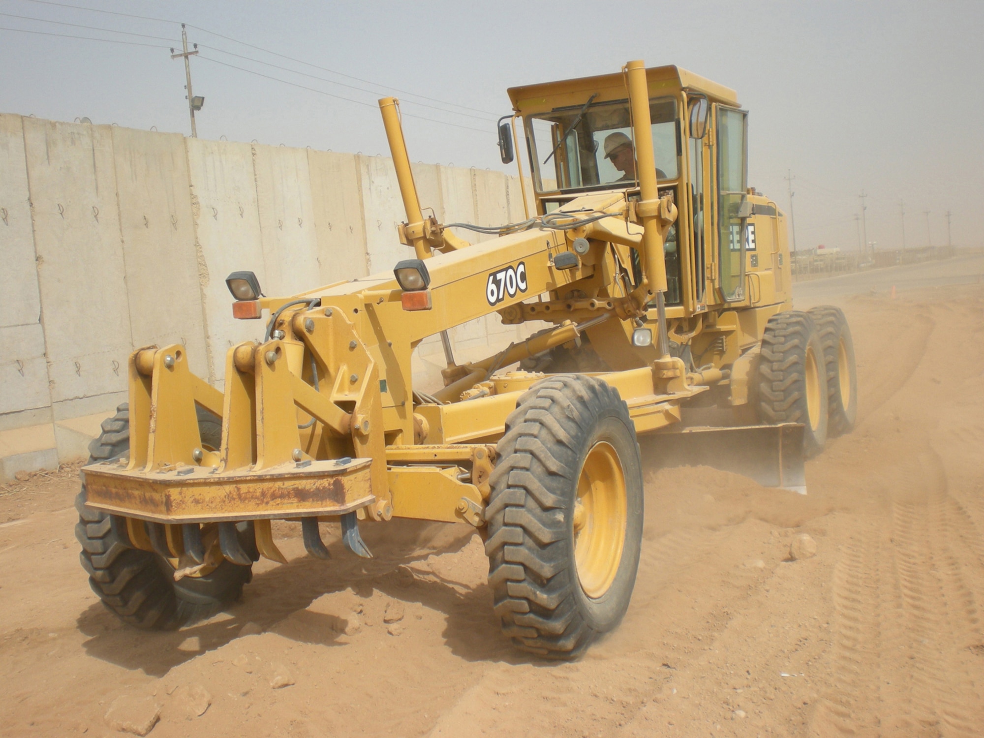 BALAD AIR BASE, Iraq -- Staff Sgt. Stephen Hansen, 732nd Expeditionary Civil Engineer Squadron heavy operator, Dirt Boyz section, grades an area of dirt to prepare it for pouring of a concrete pad at Forward Operating Base Caldwell, Iraq. Airmen from the 732 ECES Dirt Boys poured almost 1,577 cubic yards of concrete during three separate pad projects at the FOB. These pads will allow the Soldiers to perform maintenance on their vehicles without having to be in the dirt and mud. Sergeant Hansen is deployed from Holloman Air Force Base, N.M. (U.S. Air Force photo/ Staff Sgt. Josh Jeffreys)