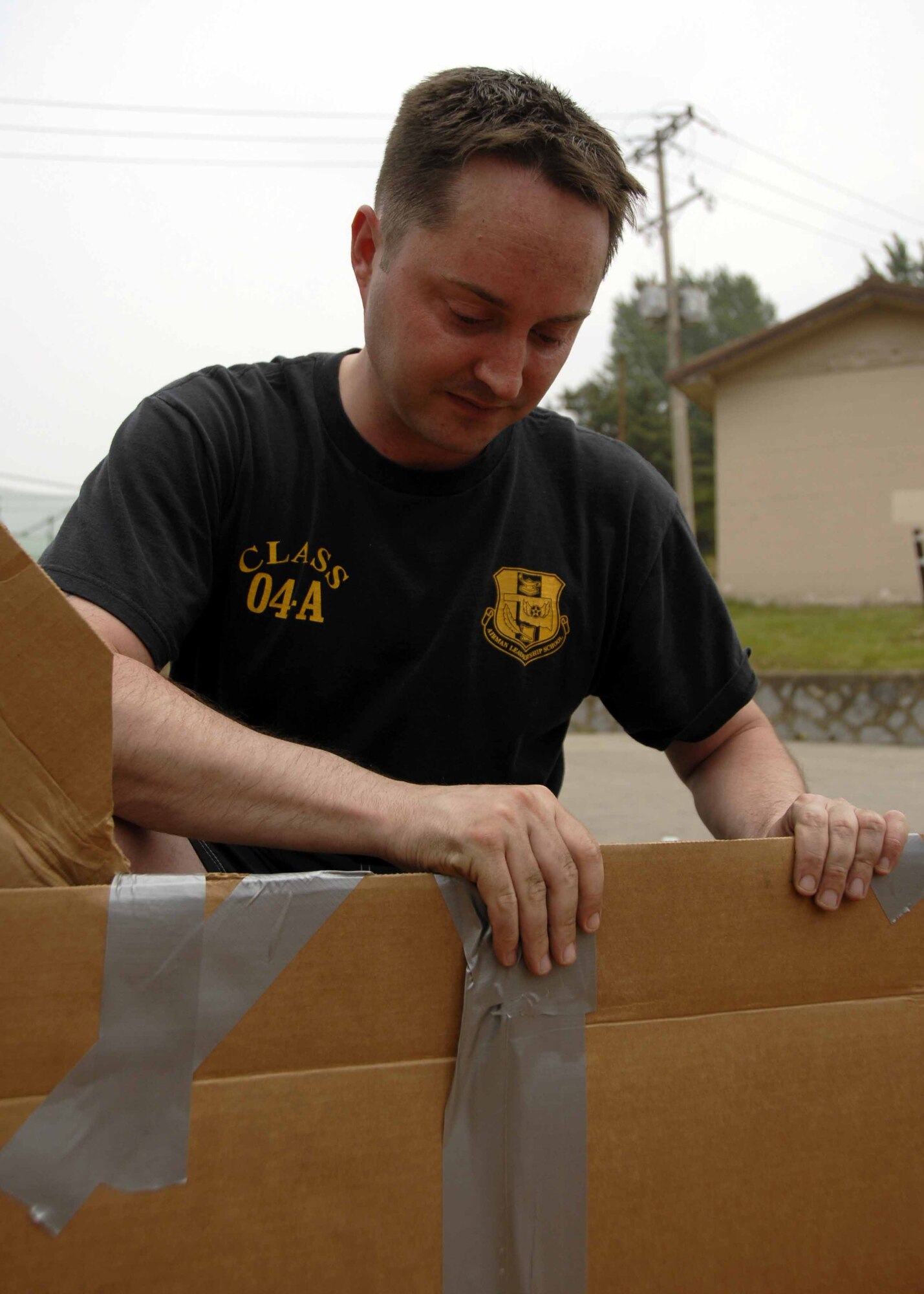 OSAN AIR BASE, Republic of Korea – Staff Sgt. Erik Milton, 51st Medical Support Squadron biomedical equipment repair technician, smoothes out duct tape on his boat before the build-a-boat contest held at the base’s outdoor pool May 23. The contest was held in conjunction with 51st Fighter Wing’s 101 Critical Days of Summer burger burn. (U.S. Air Force photo by Senior Airman Christopher Boitz)