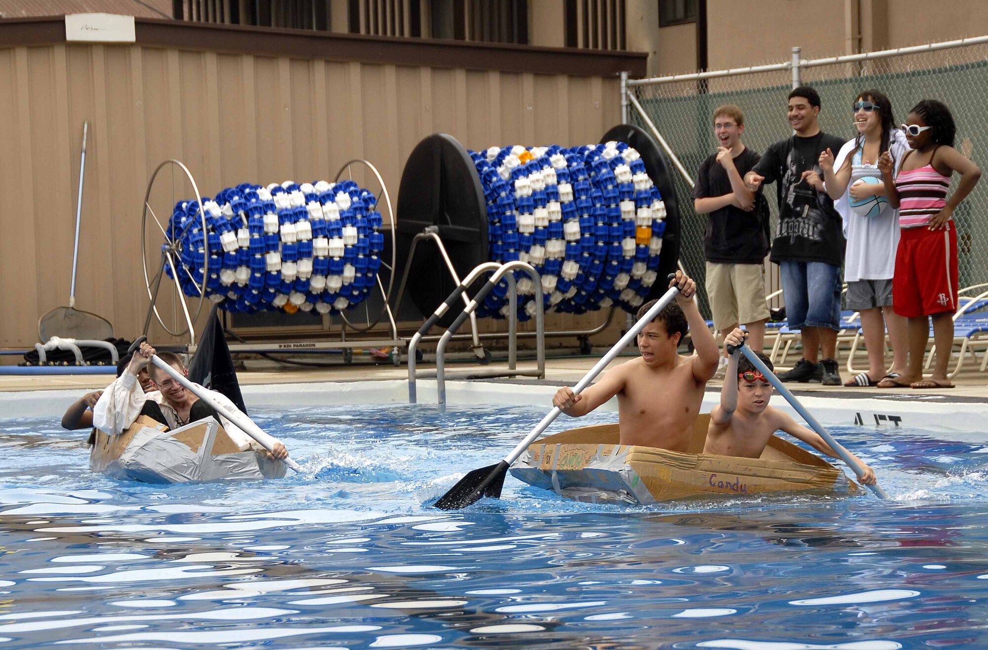 OSAN AIR BASE, Republic of Korea – Participants paddle hard towards the half way point during the build-a-boat contest at the base’s outdoor pool May 23. (U.S. Air Force photo/Senior Airman Christopher Boitz)