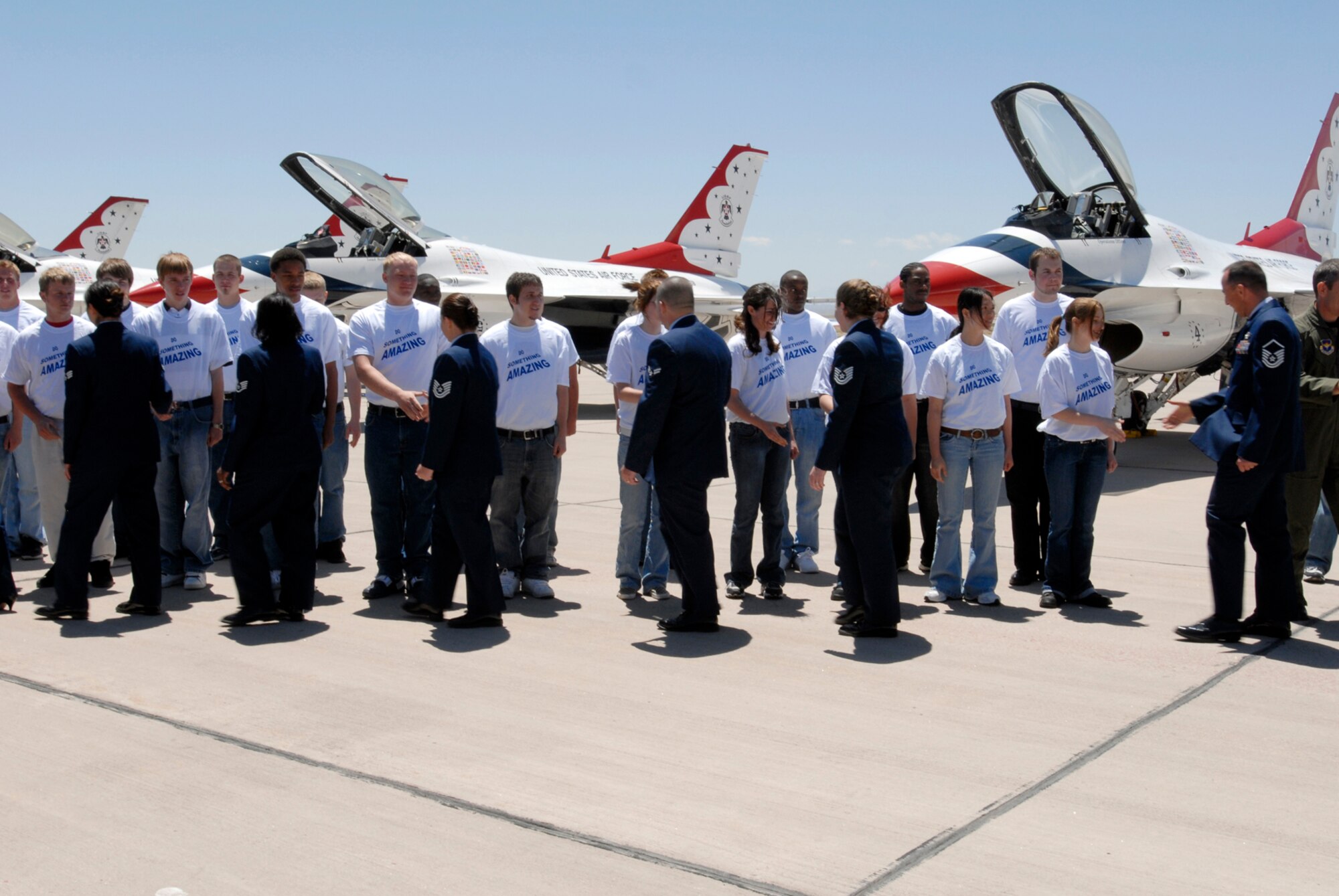 Newly enlisted Airmen and Airmen who recently re-enlisted shake hands after a re-enlistment ceremony on the Peterson flight line. Fifty Airmen enlisted and ten re-enlisted during the back-to-back ceremonies May 25. (U.S. Air Force Photo by Roberta McDonald)