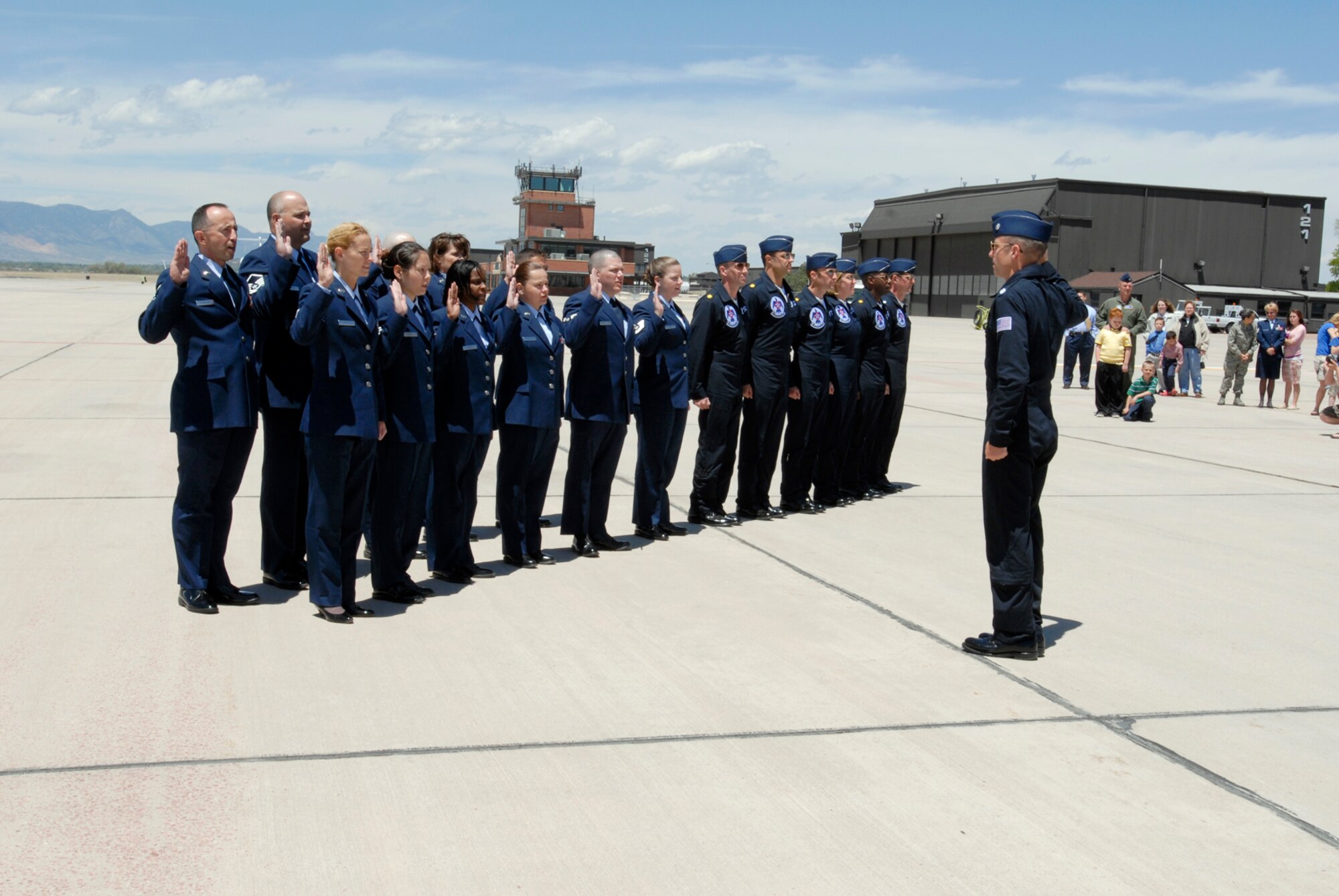 Thunderbirds commander Lt. Col. Craig Thomas, leads about 10 Airmen in the oath of enlistment during a re-enlistment ceremony on the Peterson flight line. Fifty Airmen enlisted and ten re-enlisted during the back-to-back ceremonies May 25. (U.S. Air Force Photo by Roberta McDonald)