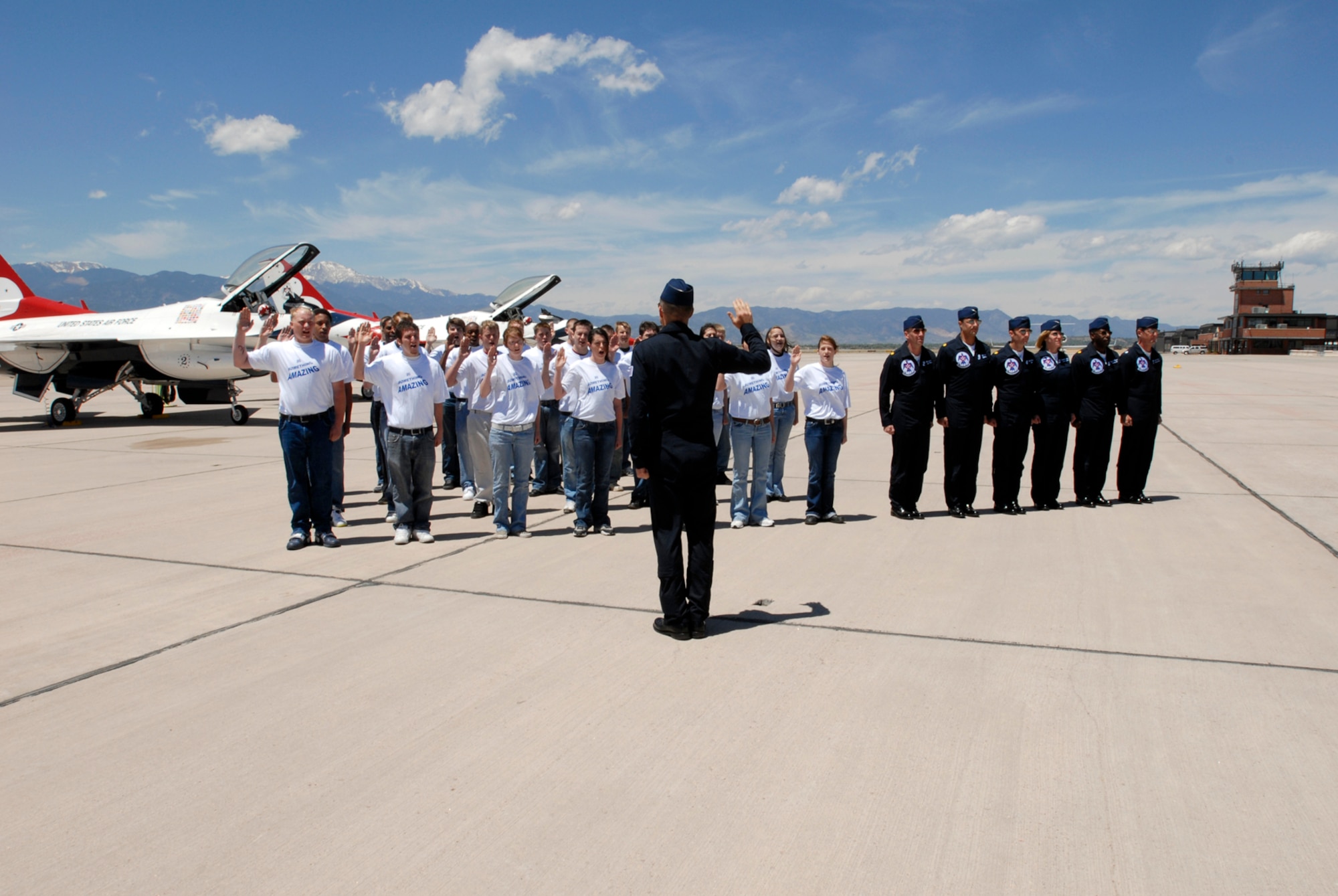 Thunderbirds commander Lt. Col. Craig Thomas, leads about 50 newly minted Airmen in the oath of enlistment during an enlistment ceremony on the Peterson flight line. Fifty Airmen enlisted and ten re-enlisted during the back-to-back ceremonies May 25. (U.S. Air Force Photo by Roberta McDonald)