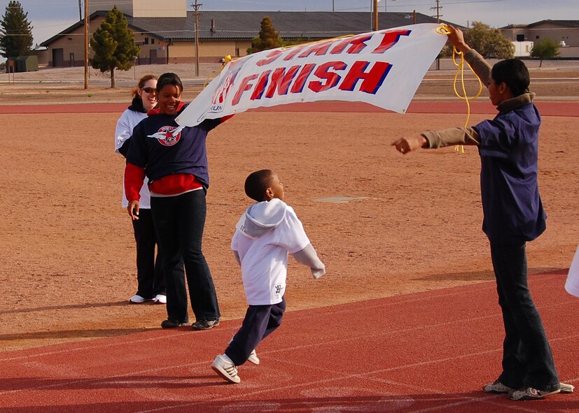 A child from Holloman Air Force Base, N.M., finishes the run at America's Kids Run at the base fitness center,  May 17. Over the years 120,000 children have completed the annual spring run. (U.S. Air Force photo/Airman 1st Class Michael Means)