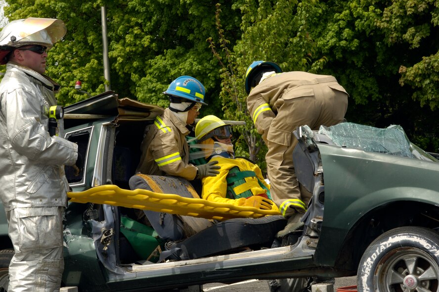 FAIRCHILD AIR FORCE BASE, Wash. – Shawn Welch, 92nd Civil Engineer Squadron firefighter; Airman 1st Class Marc Villano, 92nd Medical Operations Squadron emergency medical technician; and Senior Airman Edward Crowe, 92nd MDOS paramedic, remove Col. Roger Watkins, 92nd Air Refueling Wing vice commander, from a wrecked car during a vehicle extrication exercise at the Summer Fun and Safety Fair here May 22. (U.S. Air Force photo / Airman 1st Class Melissa Barnett)