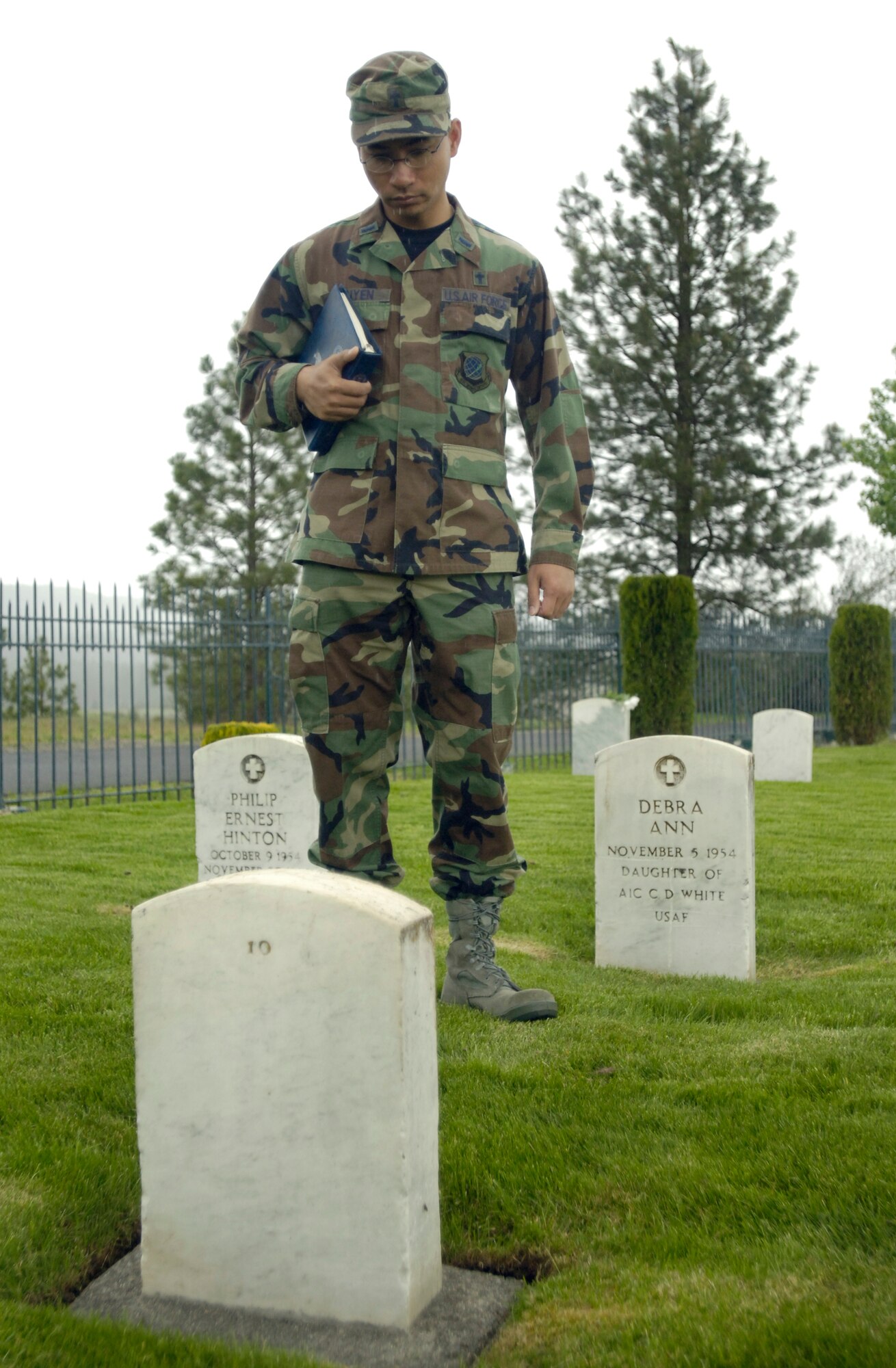 Spokane, Wash. – Chaplain (1 Lt.) Hoang Nguyen pays homage to fallen comrades at Ft. Wright cemetery here May 22. (U.S. Air Force photo/Staff Sgt. Chad Watkins) 