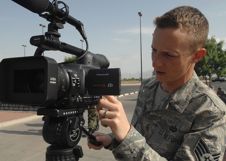Staff Sgt. Kyle Smith, 355th Fighter Wing Public Affairs, sets his video camera up to video tape the Tech. Sgt. Arthur Benko Dedication at the base fitness center May 22.  Sergeant Smith is responsible for video historical documentation of base events. (U.S. Air Force photo by Senior Airman Jacqueline Hawkins)