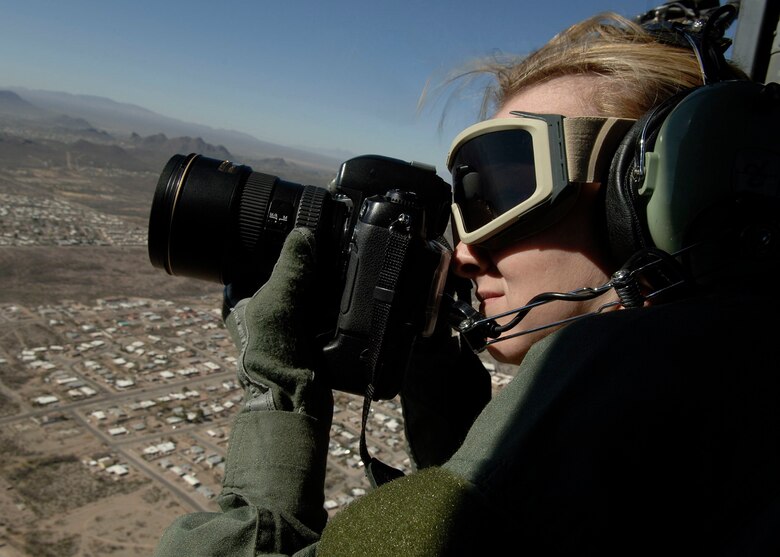 Senior Airman Alesia Goosic, 355th Fighter Wing Public Affairs still photography, takes photos out of an HH-60 Helicopter during an aerial flight over Tucson. Airman is trained to tell the Air Forces story and everything going on at D-M. (U.S. Air Force photo by Staff Sgt. Christina Kinsey)