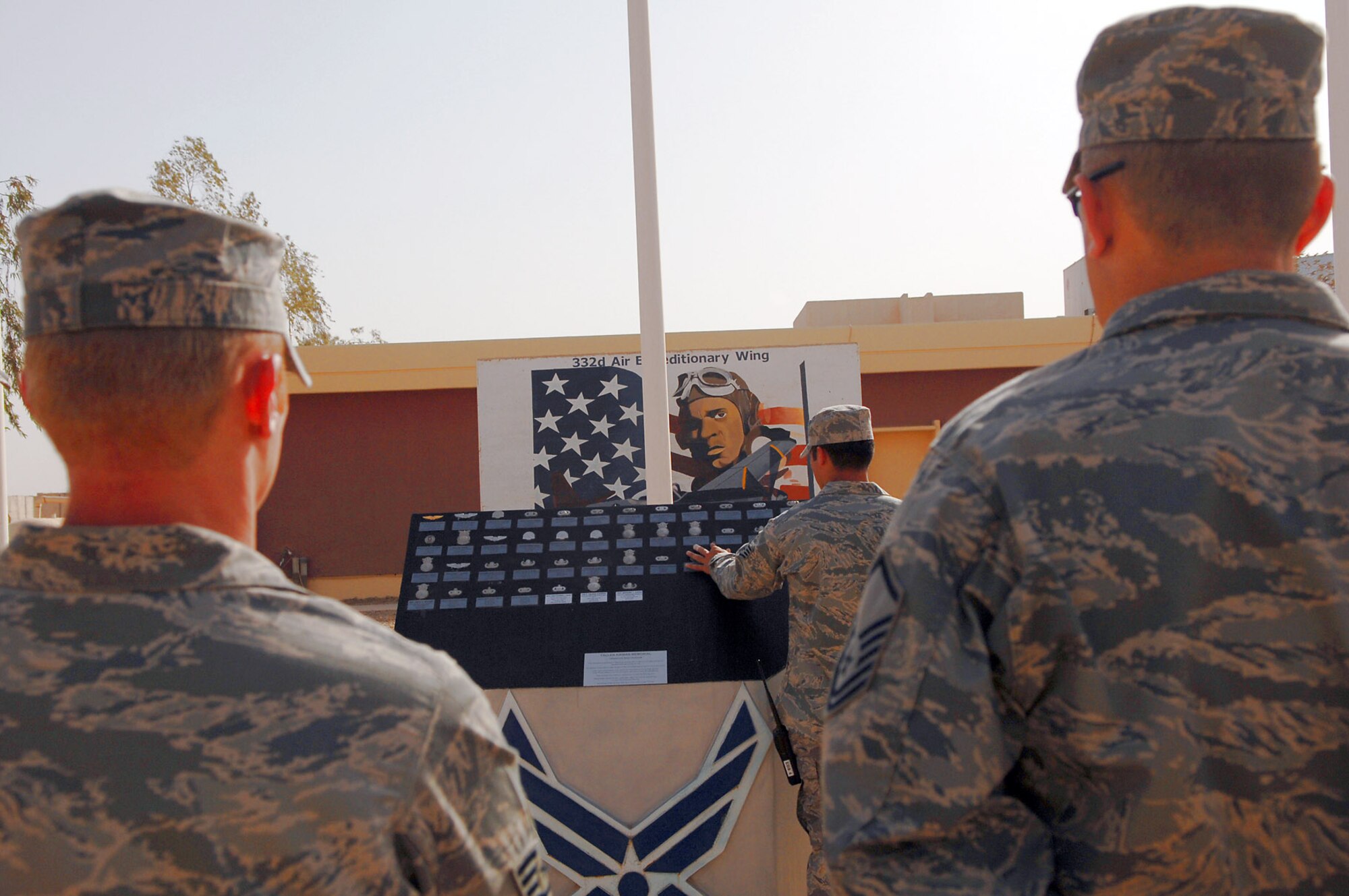 Airmen assigned to the 332nd Air Expeditionary Wing at Balad Air Base, Iraq, read the Airman?s Memorial following a Memorial Day observance ceremony May 26. During the ceremony, the names of 44 Airmen assigned to the 332nd AEW who died since 2003 were read. Those names, along with the deceased Airmen?s Air Force specialty code badges, are displayed on the Airman?s Memorial. (U.S. Air Force photo/Senior Airman Julianne Showalter)