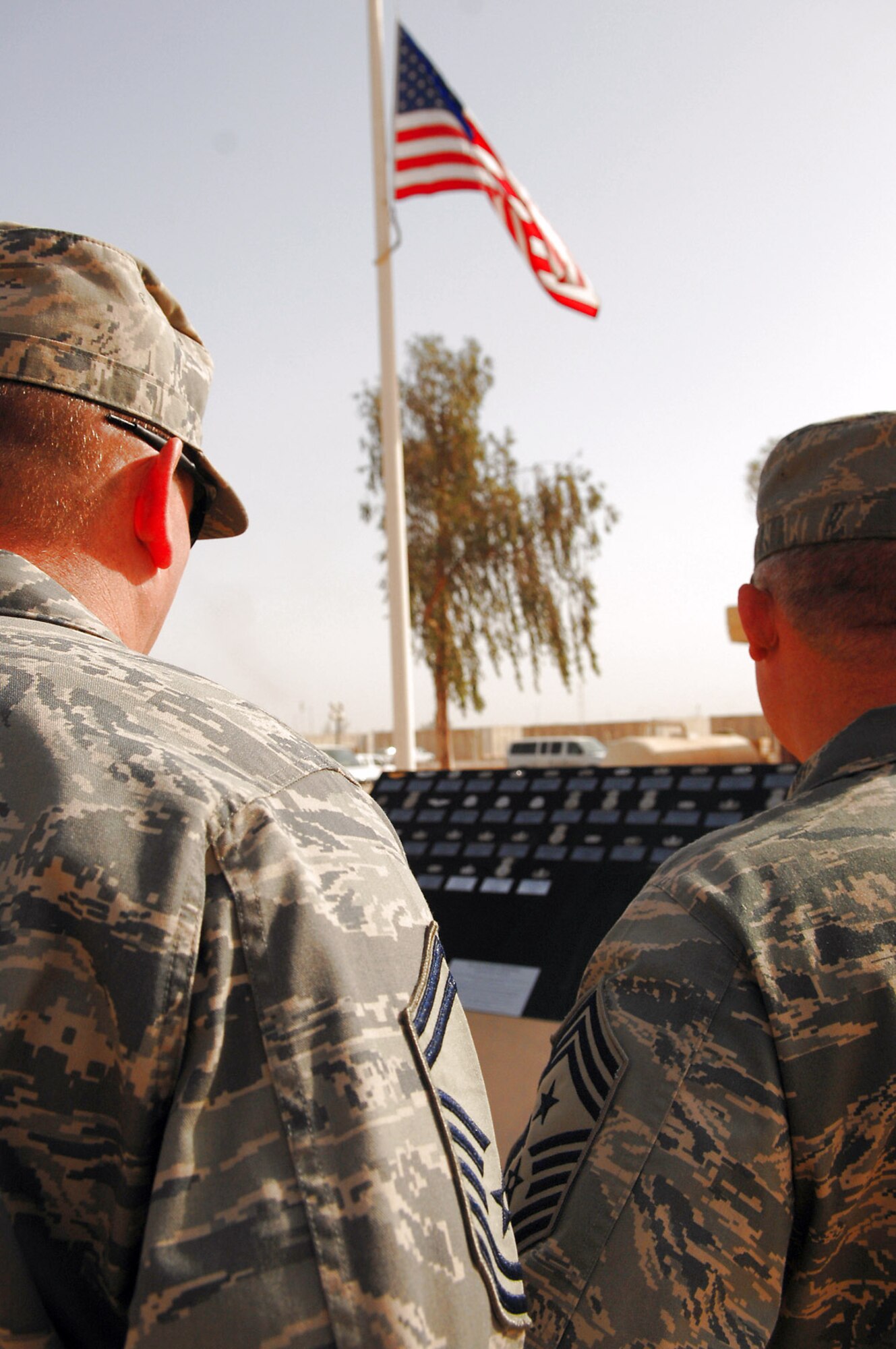 Airmen assigned to the 332nd Air Expeditionary Wing at Balad Air Base, Iraq, read the Airman?s Memorial following a Memorial Day observance ceremony May 26. During the ceremony, the names of 44 Airmen assigned to the 332nd AEW who died since 2003 were read. Those names, along with the deceased Airmen?s Air Force specialty code badges, are displayed on the Airman?s Memorial. (U.S. Air Force photo/Senior Airman Julianne Showalter)