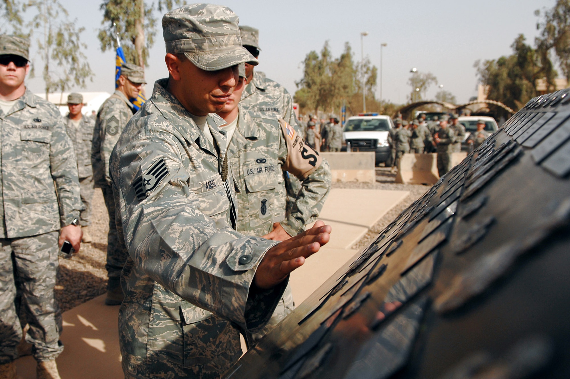 Airmen assigned to the 332nd Air Expeditionary Wing at Balad Air Base, Iraq, read the Airman?s Memorial following a Memorial Day observance ceremony May 26. During the ceremony, the names of 44 Airmen assigned to the 332nd AEW who died since 2003 were read. Those names, along with the deceased Airmen?s Air Force specialty code badges, are displayed on the Airman?s Memorial. (U.S. Air Force photo/Senior Airman Julianne Showalter)