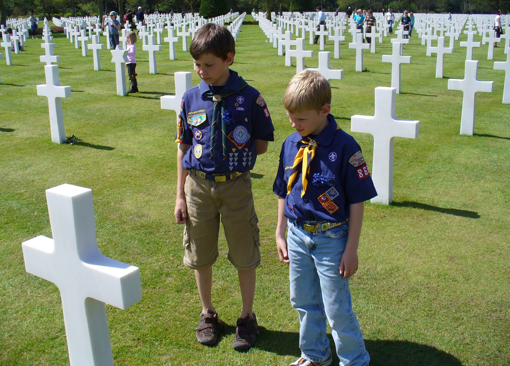 Cub Scouts Severin Blenkush III, age 10, and his brother Garrett, 7, see first hand the cost of freedom as they look over the headstones of fallen U.S. servicemembers in Normandy, France, recently. More than 3,600 scouts descended on the beachhead and surrounding area April 25-27 for a beach cleaning service project followed by a memorial service on Omaha Beach. The scouts are sons to Lt. Col. Severin Blenkush, commander, Detachment 1, 21st Contracting Squadron. (Courtesy photo)