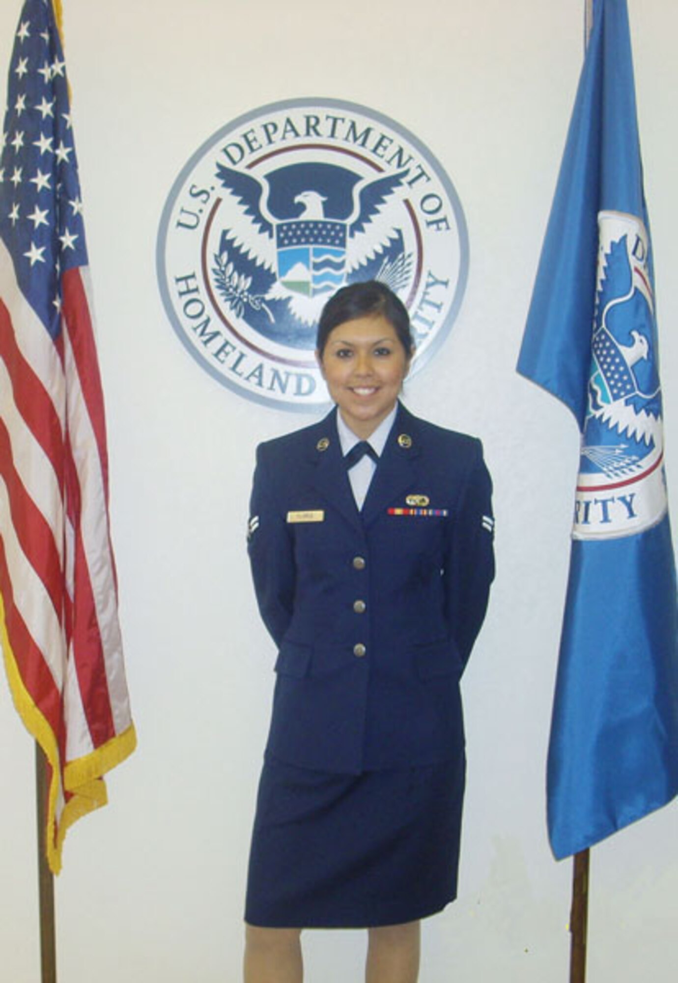 Airman First Class Nimsi Garza, a lodging technician with the 507th Air Refueling Wing Services Flight stands with pride beside the U.S. flag immediately after becoming a U.S. citizen.