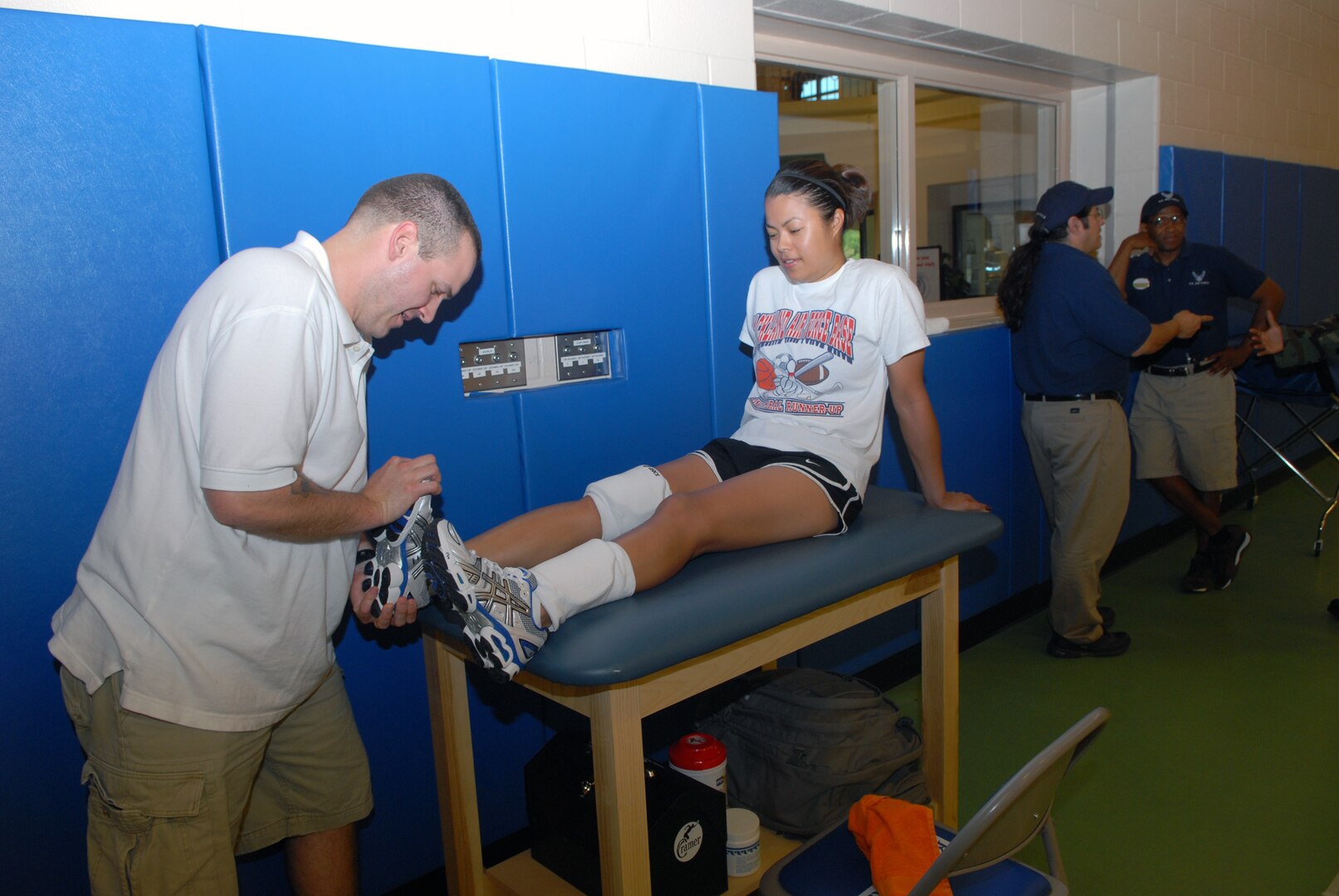 Staff Sgt. Zach Coyner, a Randolph Air Force Base physical therapist, examines Myreen Bueno following a team practice at the Rambler Fitness Center here.