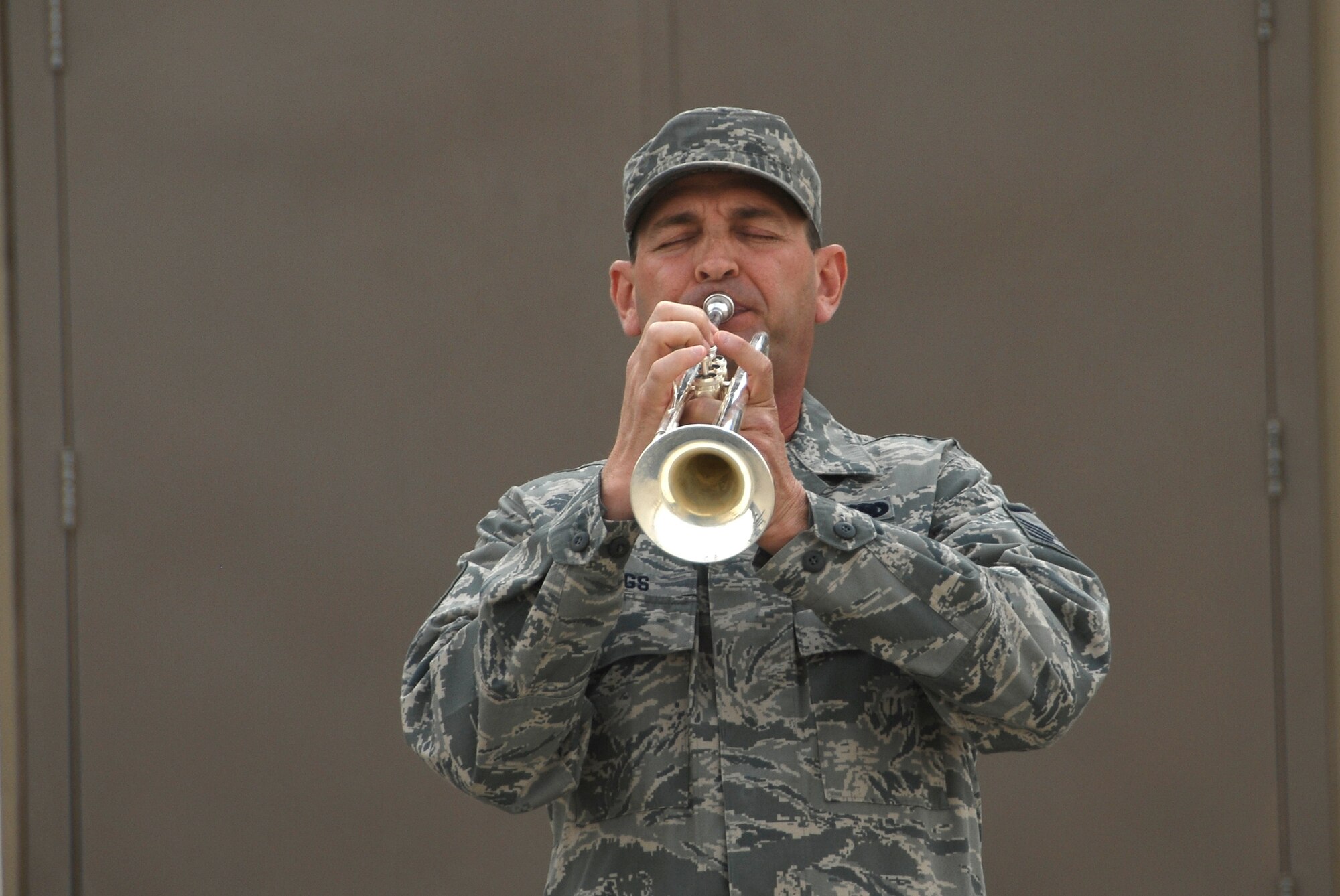 SOUTHWEST ASIA -- Master Sgt. Thomas Jennings, from the 386th Expeditionary Civil Engineer Squadron, plays taps during a Memorial Day ceremony May 26, 2008 at an air base in the Persian Gulf Region. During the ceremony, a 21-gun salute was conducted along with a laying of a wreath to honor the men and women who have died in military service. (U.S. Air Force photo/ Staff Sgt. Patrick Dixon)