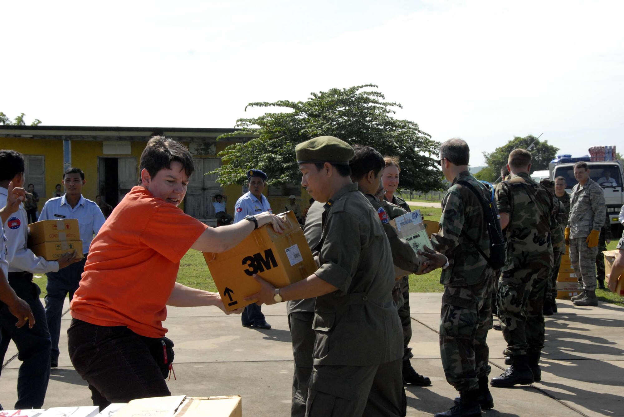 KAMPONG CHHNANG PROVINCE, Cambodia -- Master Sergeant Tracy Lewis (left), from Pacific Air Forces International Heath Alliance, hands off a box of medical supplies to Lieutenant Colonel Mark Sophai, a doctor with the Royal Cambodian Armed Forces here May 24. A team effort to quickly breakdown and distribute supplies to multi-national medical teams for transport to operating locations for Operation Pacific Angel was fostered between the RCAF and U.S. Air Force, active duty, reserve and National Guard members. Operation Pacific Angel is a joint/combined humanitarian assistance operation conducted in the Pacific area of responsibility in support of CDRUSPACOM capacity-building efforts.  Participating services include the Active, Reserve and National Guard components of the U.S. Air Force, U.S. Army, Royal Thai Air Force (RTAF), and Royal Cambodian Armed Forces (RCAF). U.S. Air Force photo/Tech. Sgt. Tom Czerwinski.
